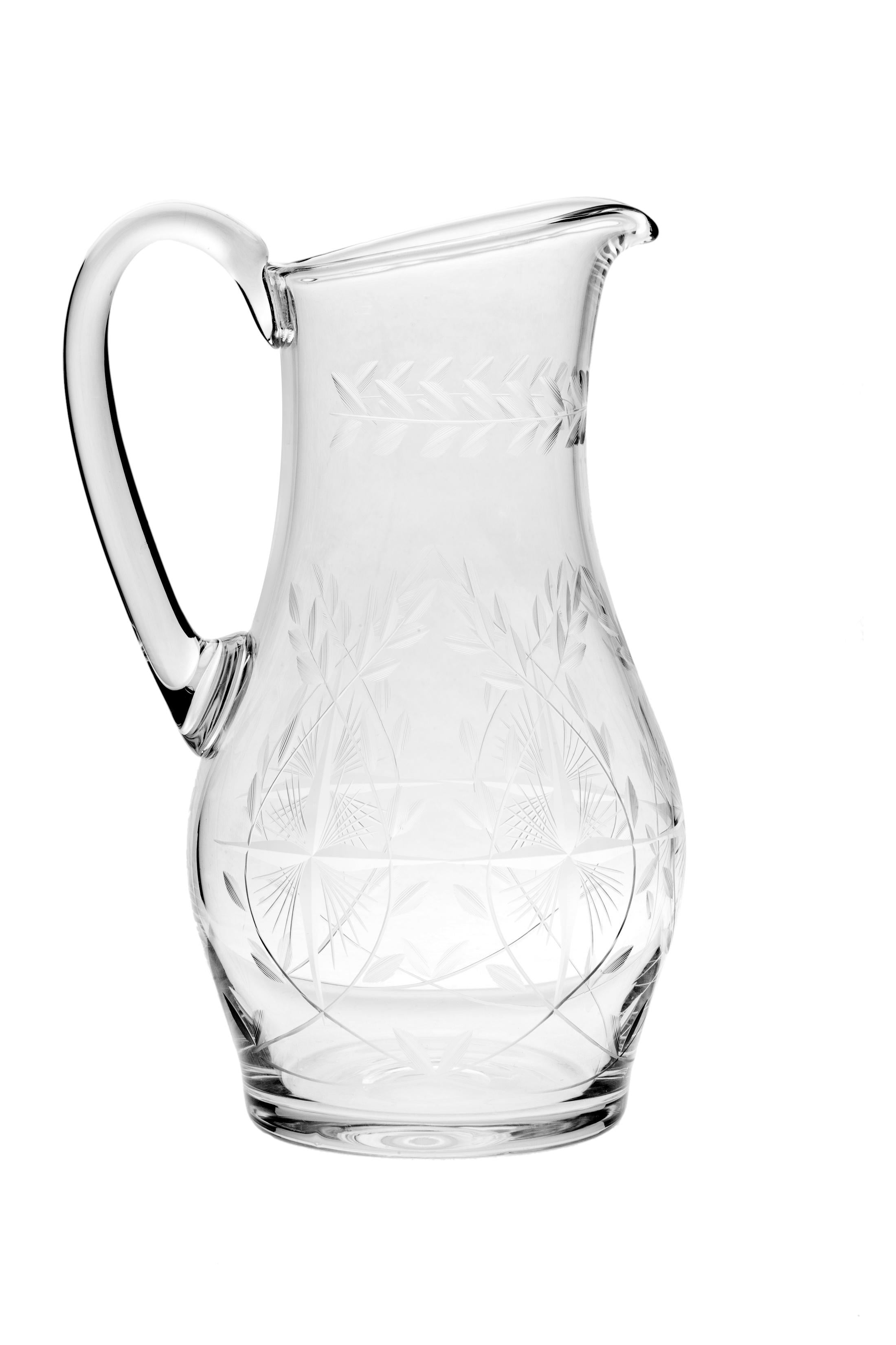An exceptionally fine hand cut crystal pitcher. This pretty pitcher has a garland of leaves circling the neck and a criss-cross cut pattern with etched swaying leaves at the base. Perfect for water, juice or Bloody Mary’s at brunch. A well balanced