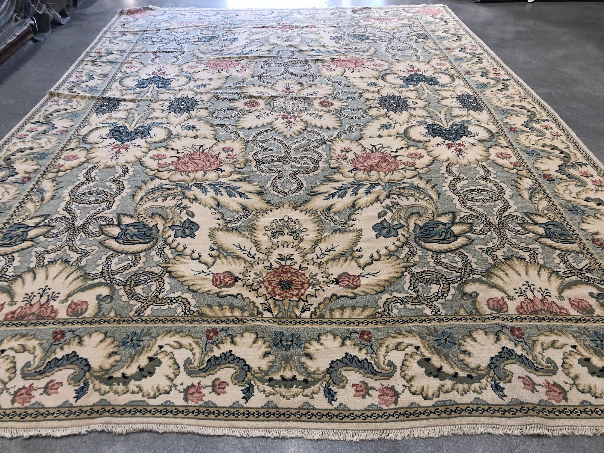 A dense, swirling floral pattern of ivory, rose and blue against a gray background highlights this stunning European Design collection wool area rug. An ideal piece for formal living or dining room or large entry hall. Hand knotted all-wool