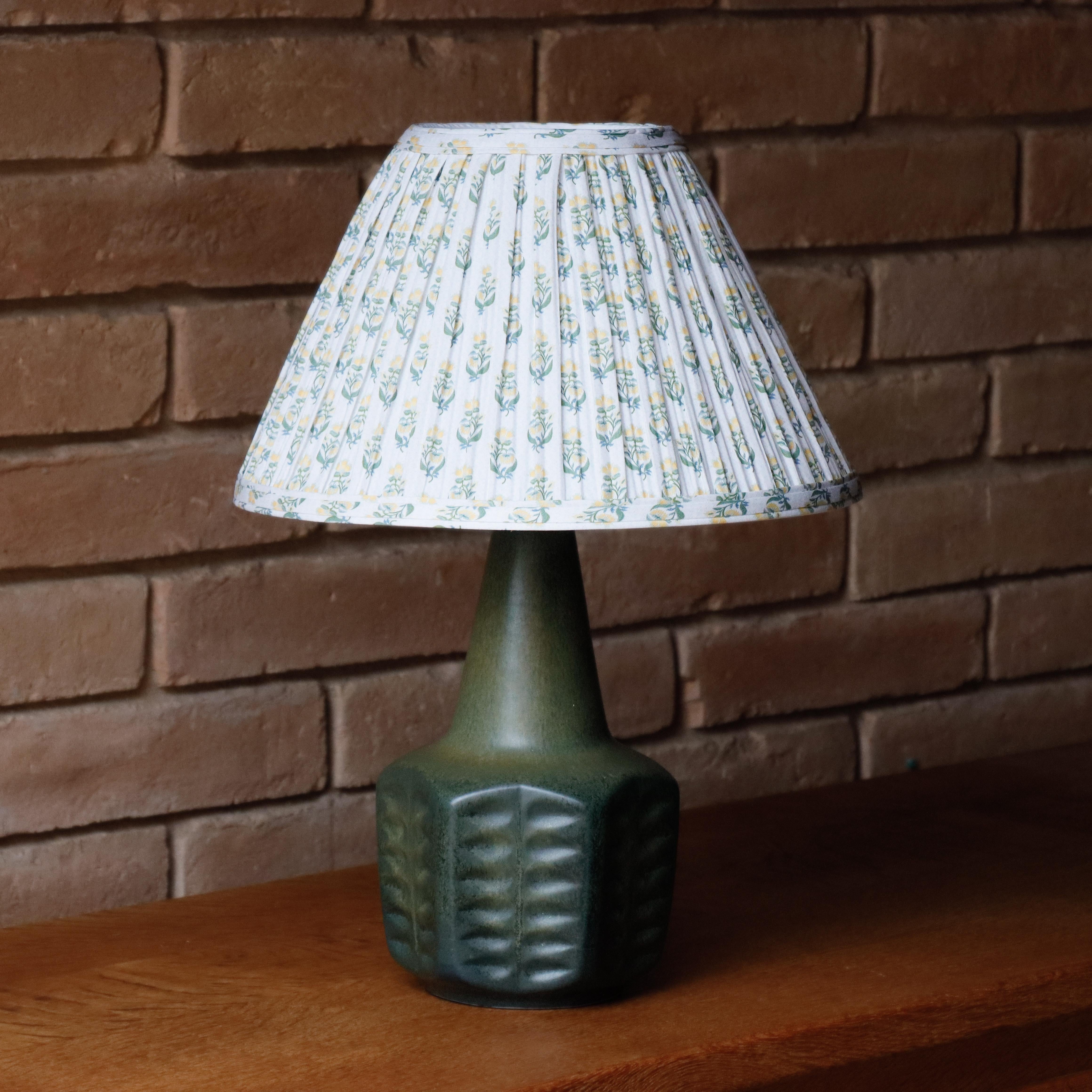 Affascinante lampada da tavolo danese di metà secolo in ceramica con dettagli geometrici che sembrano quasi botanici. La ceramica ha un bellissimo e ricco smalto. Completato con un nuovissimo paralume floreale personalizzato che completa la forma e