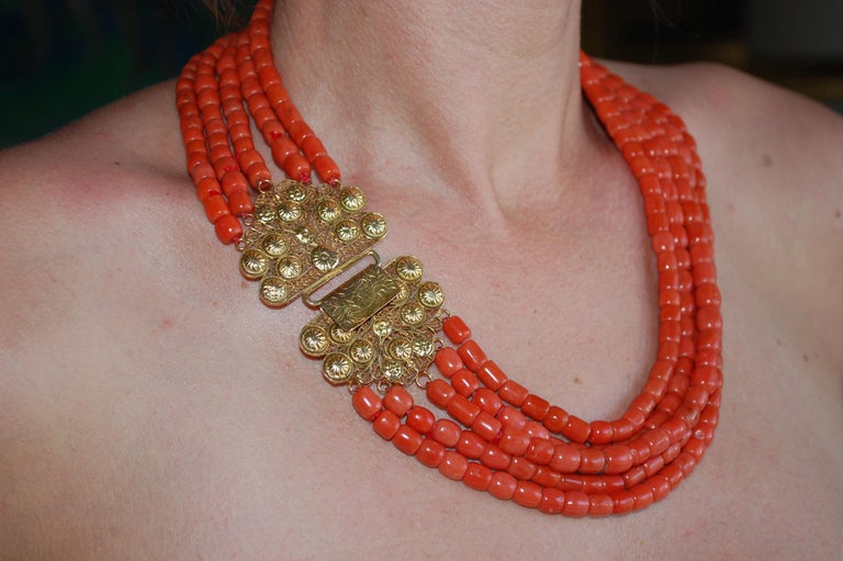 Stunning antique Coral necklace.
A five strand of fine European natural red/salmon coral  necklace beads about 6-7mm. The coral beads are barrel-shaped and the handmade clasp is made of 14k yellow gold. The clasp is absolutely gorgeous with delicate