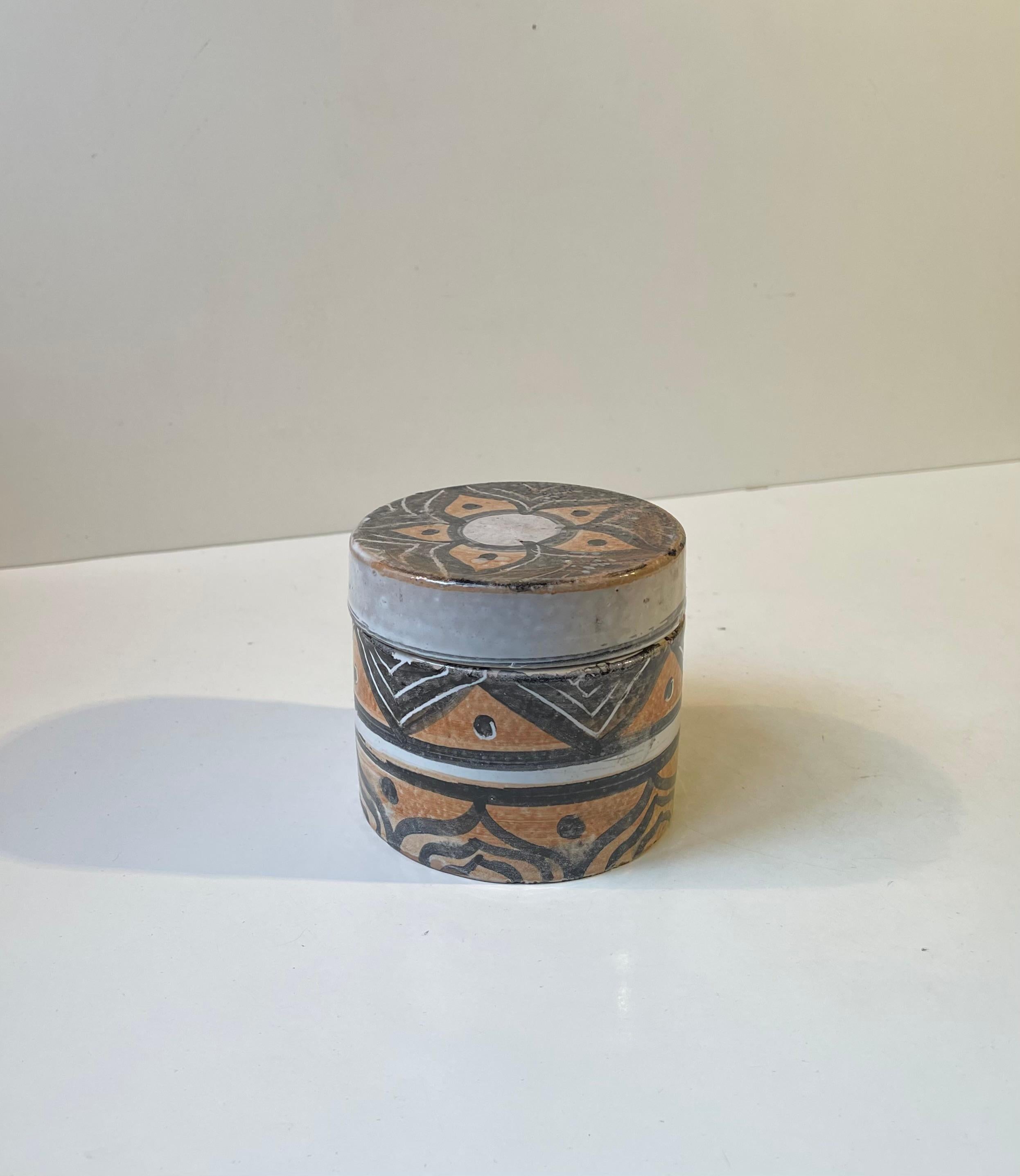 Folk Art ceramic trinket jar hand-glazed and decorated naively with floral patterns. Signed - by an un-identified Scandinavian/European ceramist circa 1970-75.   

Measurements: H: 10 cm, Diameter: 11 cm.