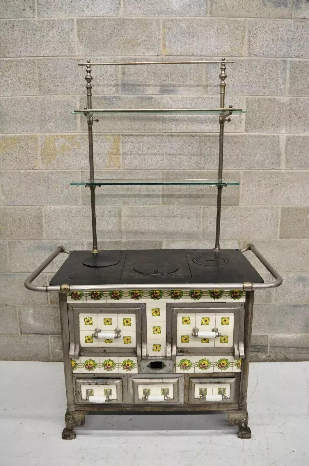 Estufa europea francesa o belga de hierro fundido Art Nouveau de leña y carbón. El artículo presenta azulejos florales estilizados esmaltados, el marco rectangular con tapa de hierro fundido que oculta el interior para rellenarlo con carbón o leña,
