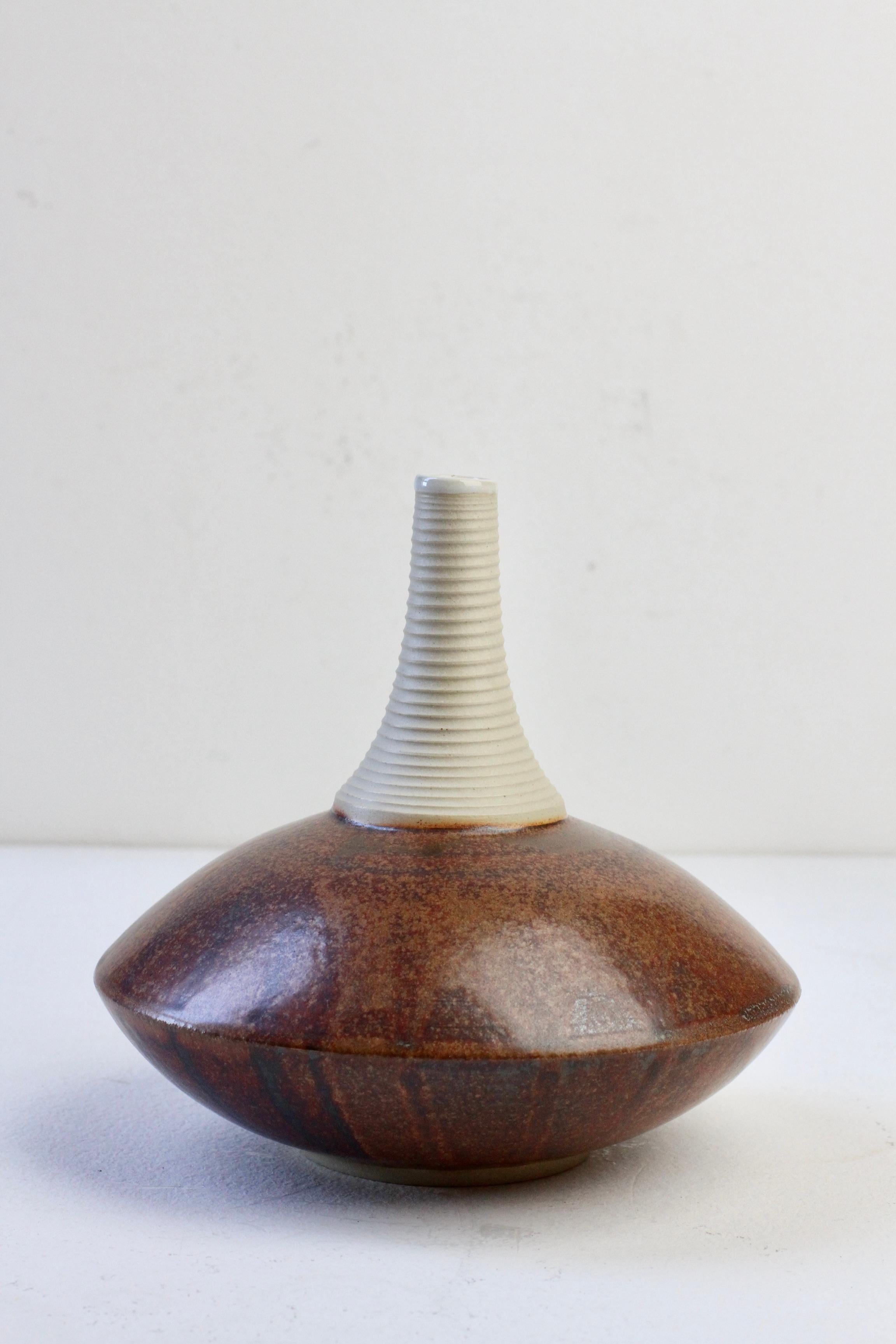This stunning European, German made hand thrown stoneware clay vase was designed and made by Hans-Georg Fischer in 2009. Beautiful, almost discus like form of the body of the vase is decorated with a wonderful brown glaze of differing hues -