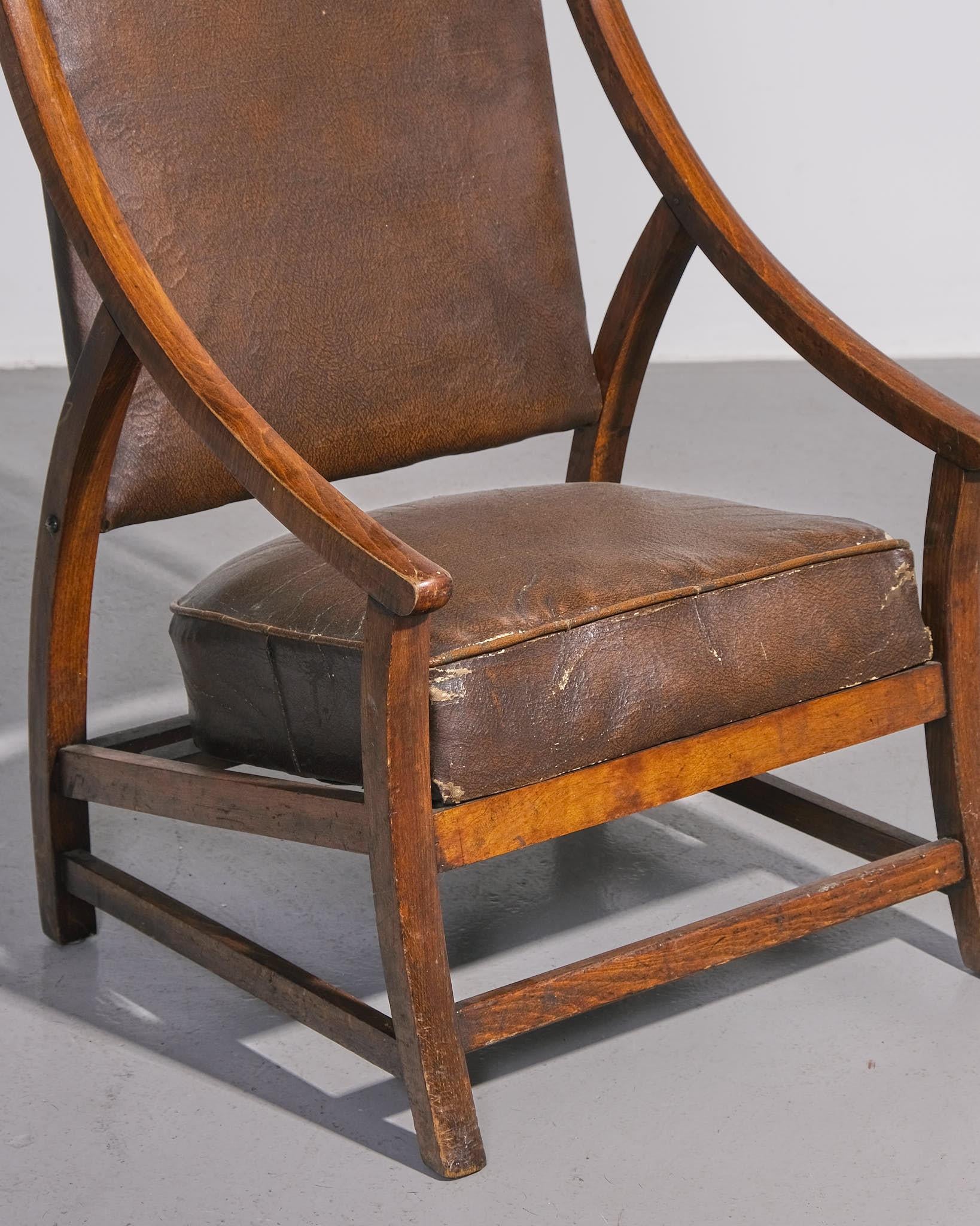 Charmante chaise de cheminée à haut dossier, fabriquée en Europe vers les années 1940. Ce meuble présente un cadre sculptural en chêne à la patine joliment vieillie, associé à son revêtement en similicuir d'origine. Le dossier haut et légèrement