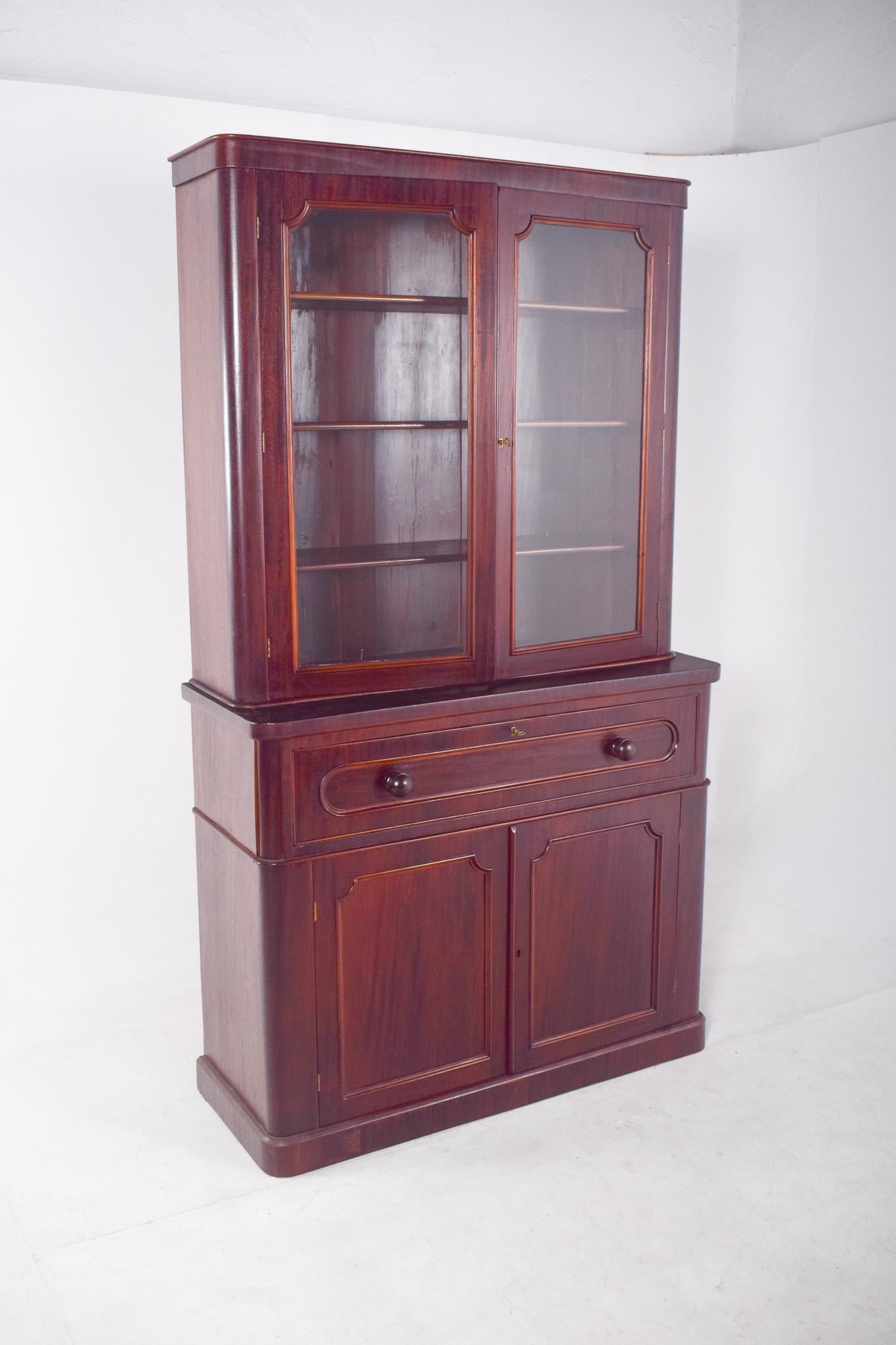 Mahogany bookcase cabinet. This piece of furniture offers classic and functional elegance, ideal for environments that value good taste and organization. With two glass doors at the top, it allows you to display crockery, glasses or decorative