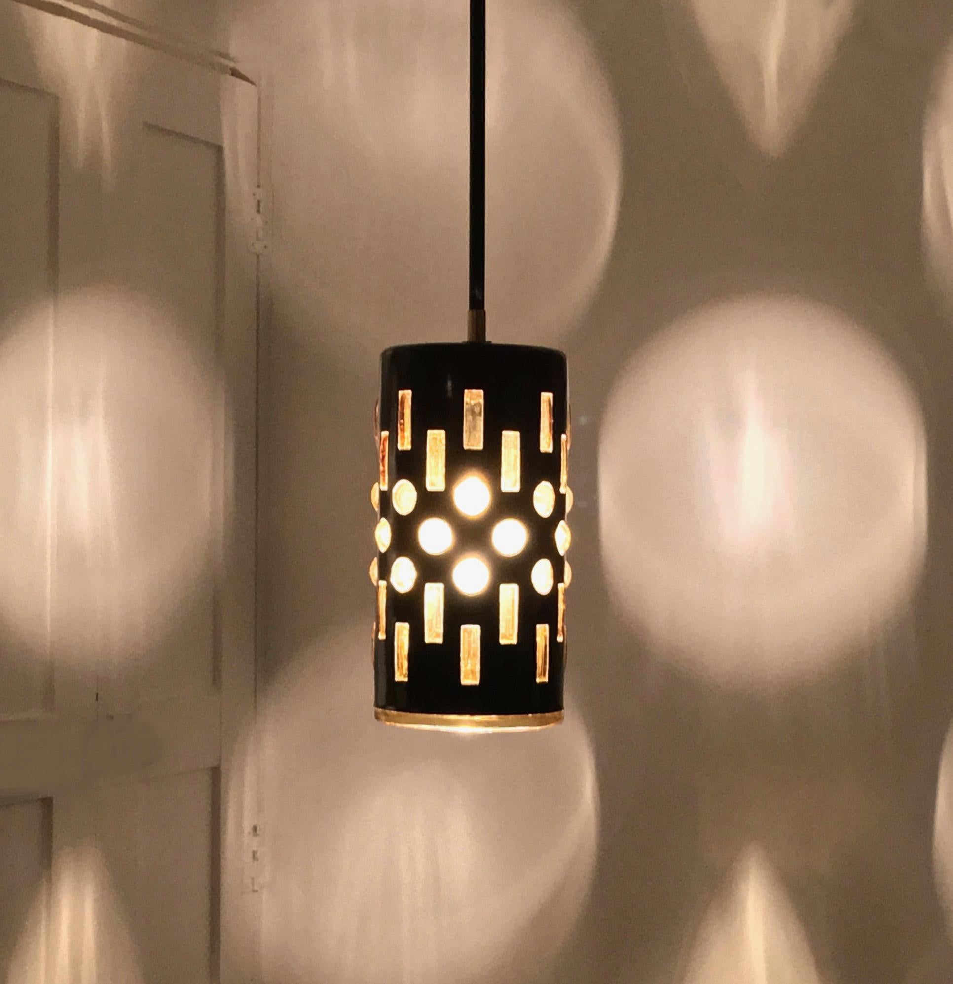 Pendant light or lantern made up of an amber-colored caged glass lining, blown into a deep blue/black enameled metal shade. European, mid-20th century.

A simple, elegant light, nicely made, which gives a lovely patterned light through the amber