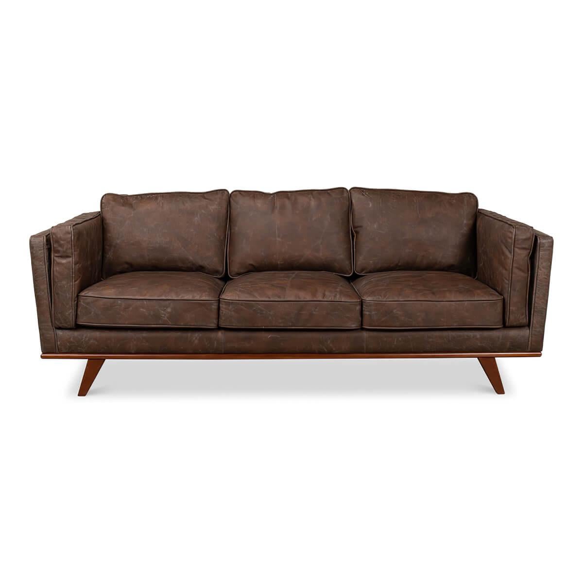 A European Mid Century Modern style three-seat sofa with antique brown leather and a dark stained maple frame with out-flaring tapered legs.

Dimensions: 90