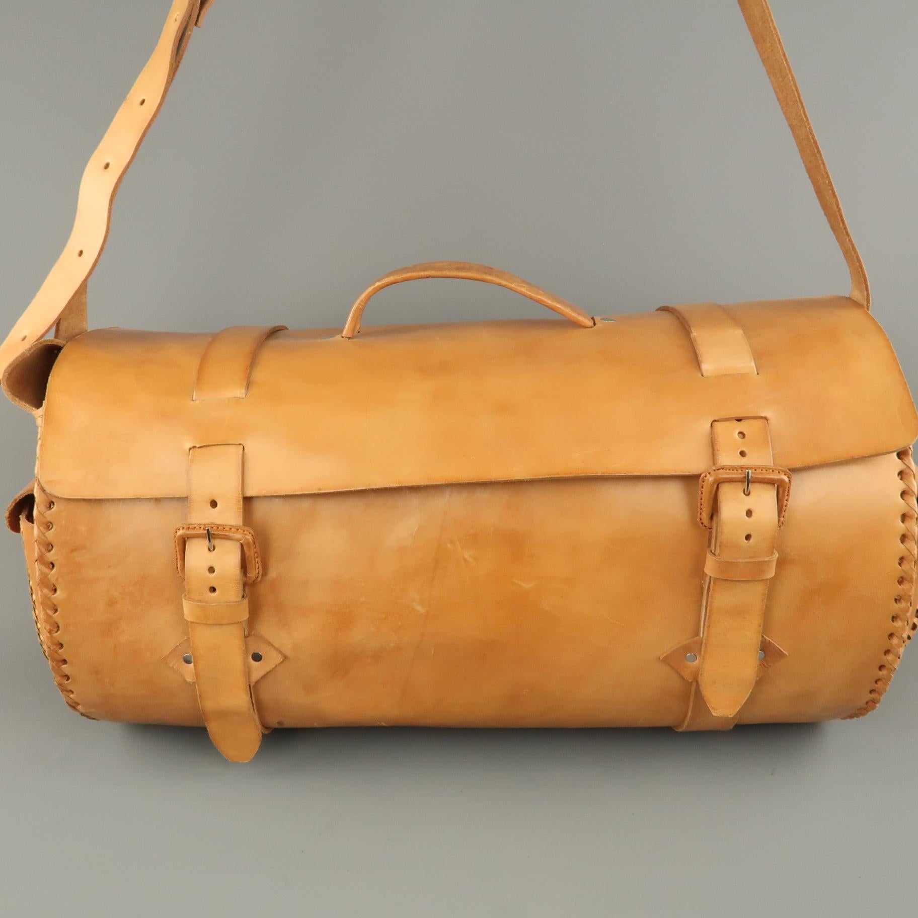 EUROPEAN NATURAL LEATHER BAGS duffel bag comes in natural tan leather with a double belted flap closure top, top handle, side pockets, woven trim, and shoulder strap. Wear throughout. As-is.
 
Good Pre-Owned Condition.
 
Measurements:
 
Length: 22