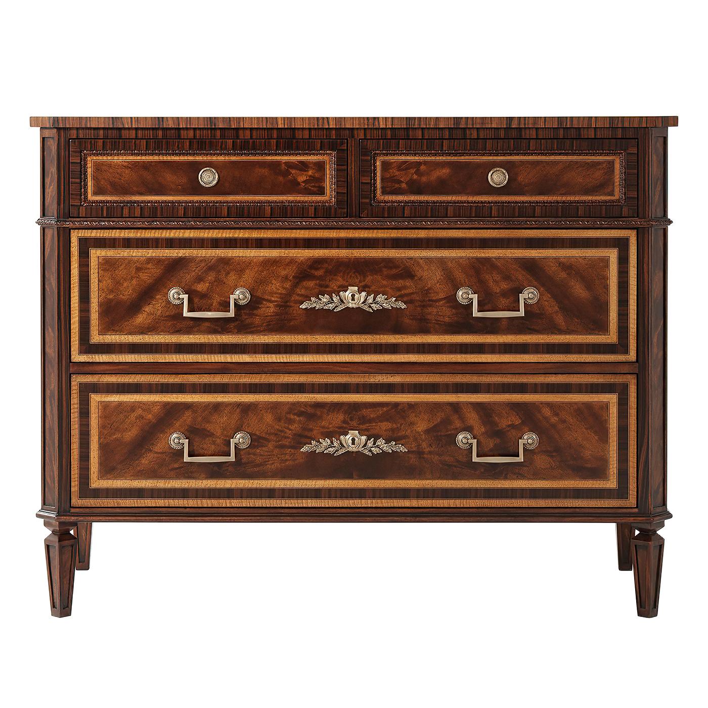 A flame mahogany, Movingue and rosewood banded chest of drawers, the rectangular top with canted corners, the two short drawers with lapette carved recessed molding, with a paper twist and rosette carved molding below with two further long drawers,