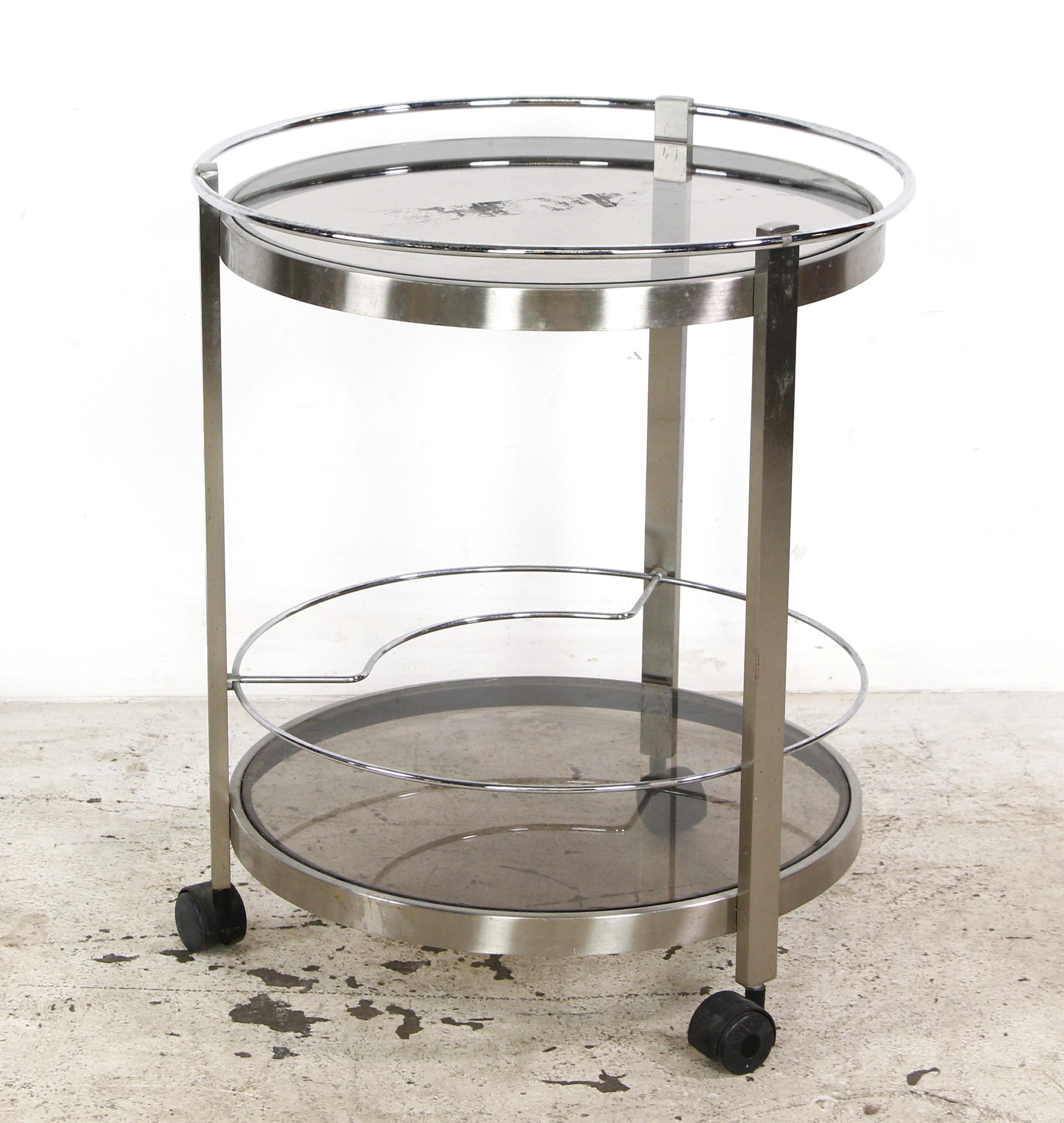 This European bar cart embodies modern elegance. With its nickeled steel frame and round tinted glass shelves, it reflects contemporary European design. This bar cart adds a touch of sophistication to spaces, offering a functional and stylish