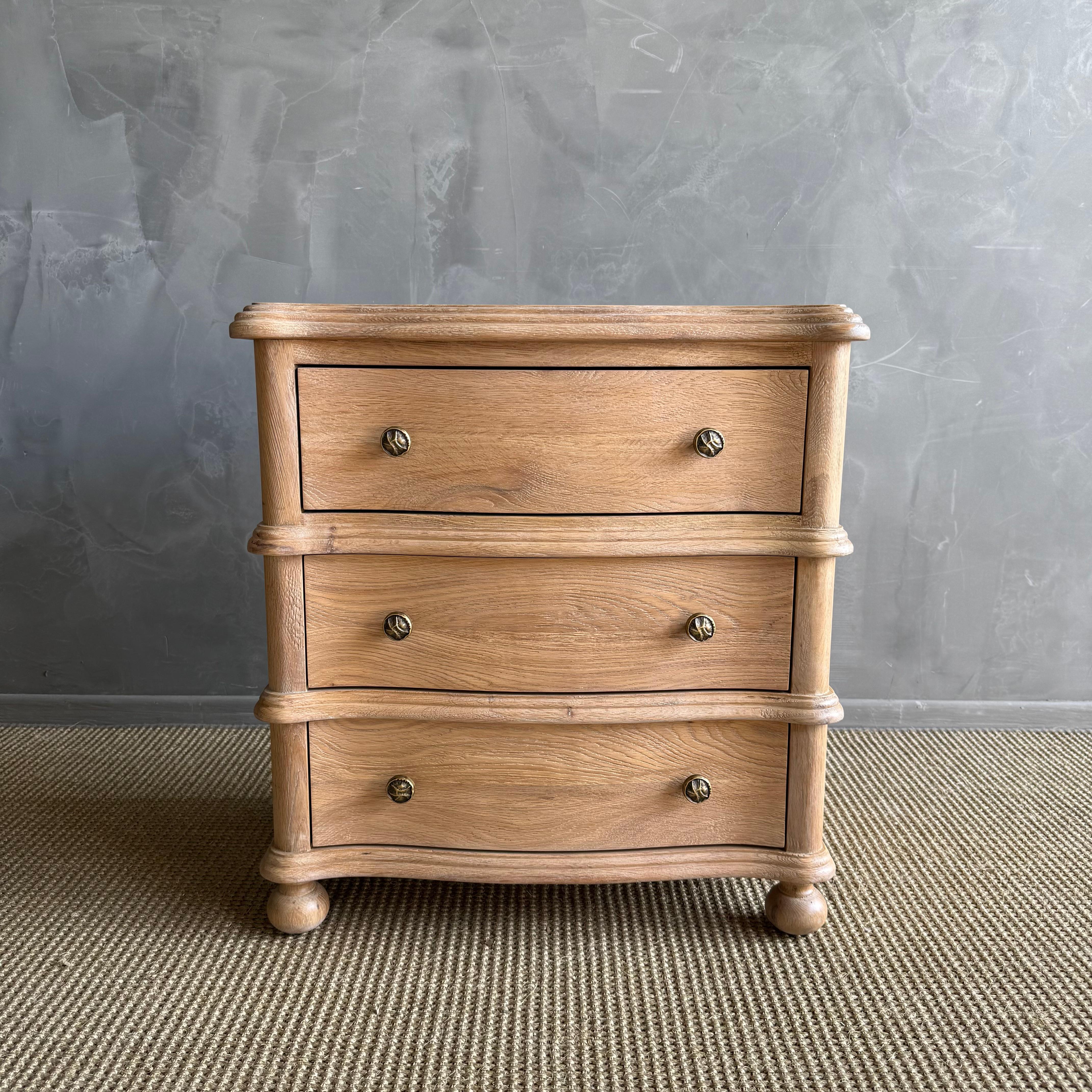 Crafted from premium European oak, this three-drawer nightstand brings timeless elegance and subtle sophistication to any bedroom. Its gently flowing serpentine front adds a graceful silhouette, highlighting the natural beauty of the wood’s grain.