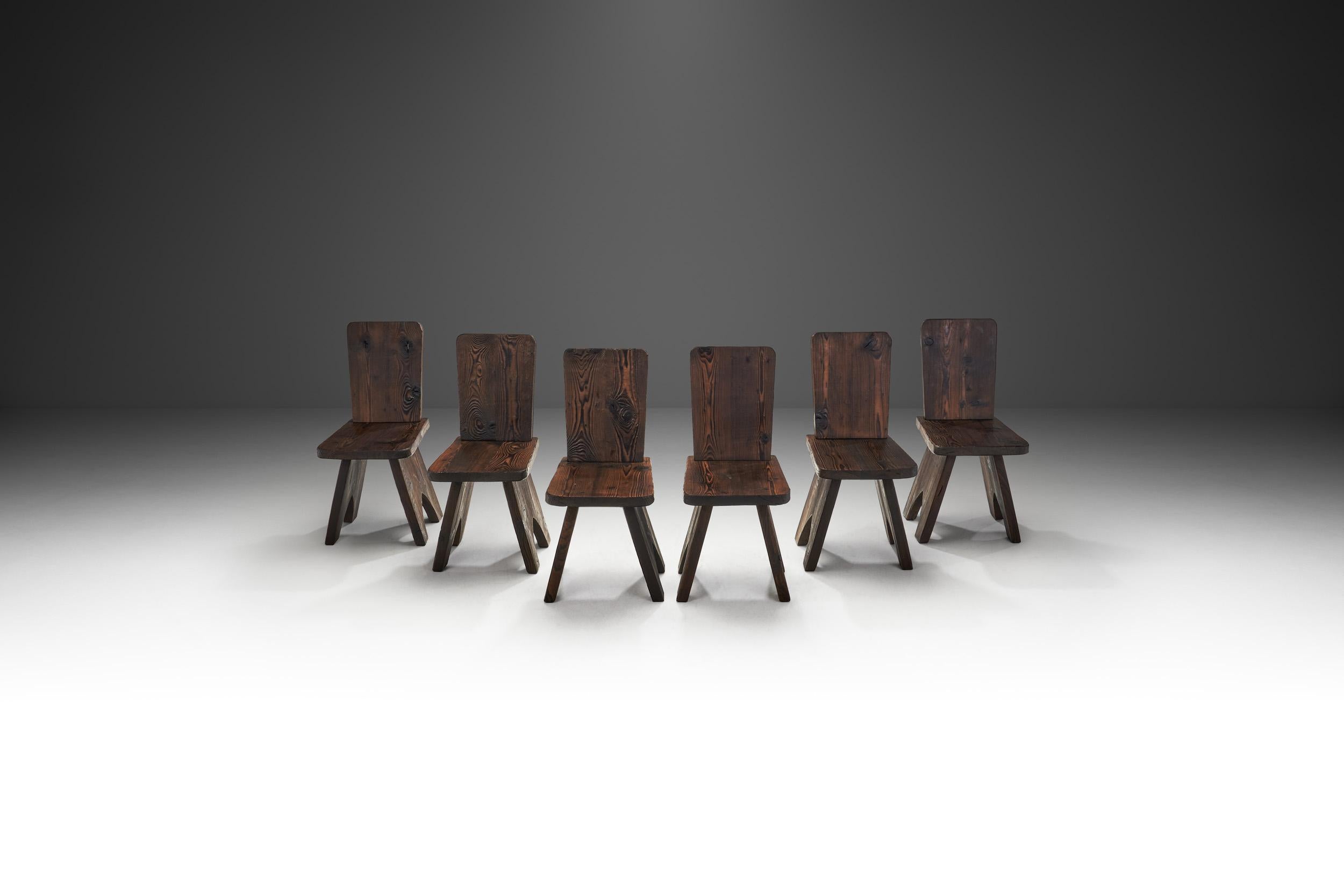 With a robust organic form and an earth-toned palette, this set of six dining chairs is the embodiment of 20th century brutalist design. In furniture and décor, the Brutalist movement was somber, giving importance to eerie organic and rugged shapes