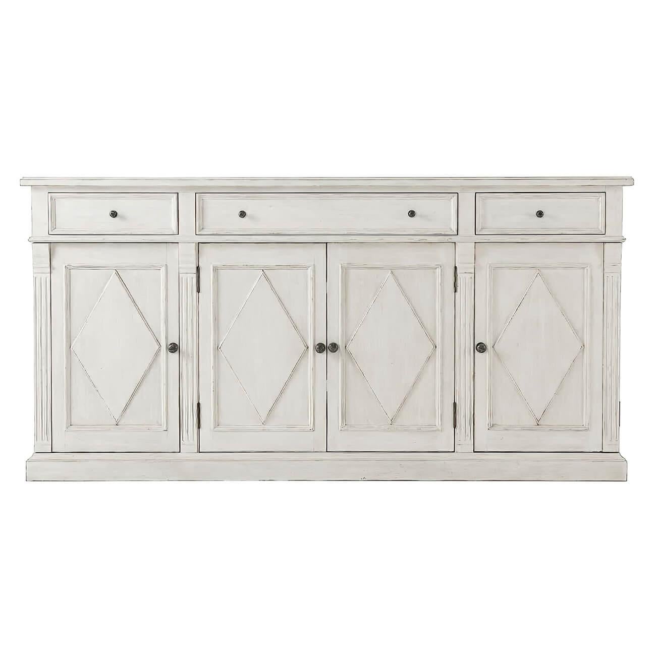 Northern European style distress painted buffet sideboard with a molded edge rectangular top, one long and two small drawers in the frieze, with lozenge paneled doors and sides, antique pewter handles, and carved fluted details on a square plinth