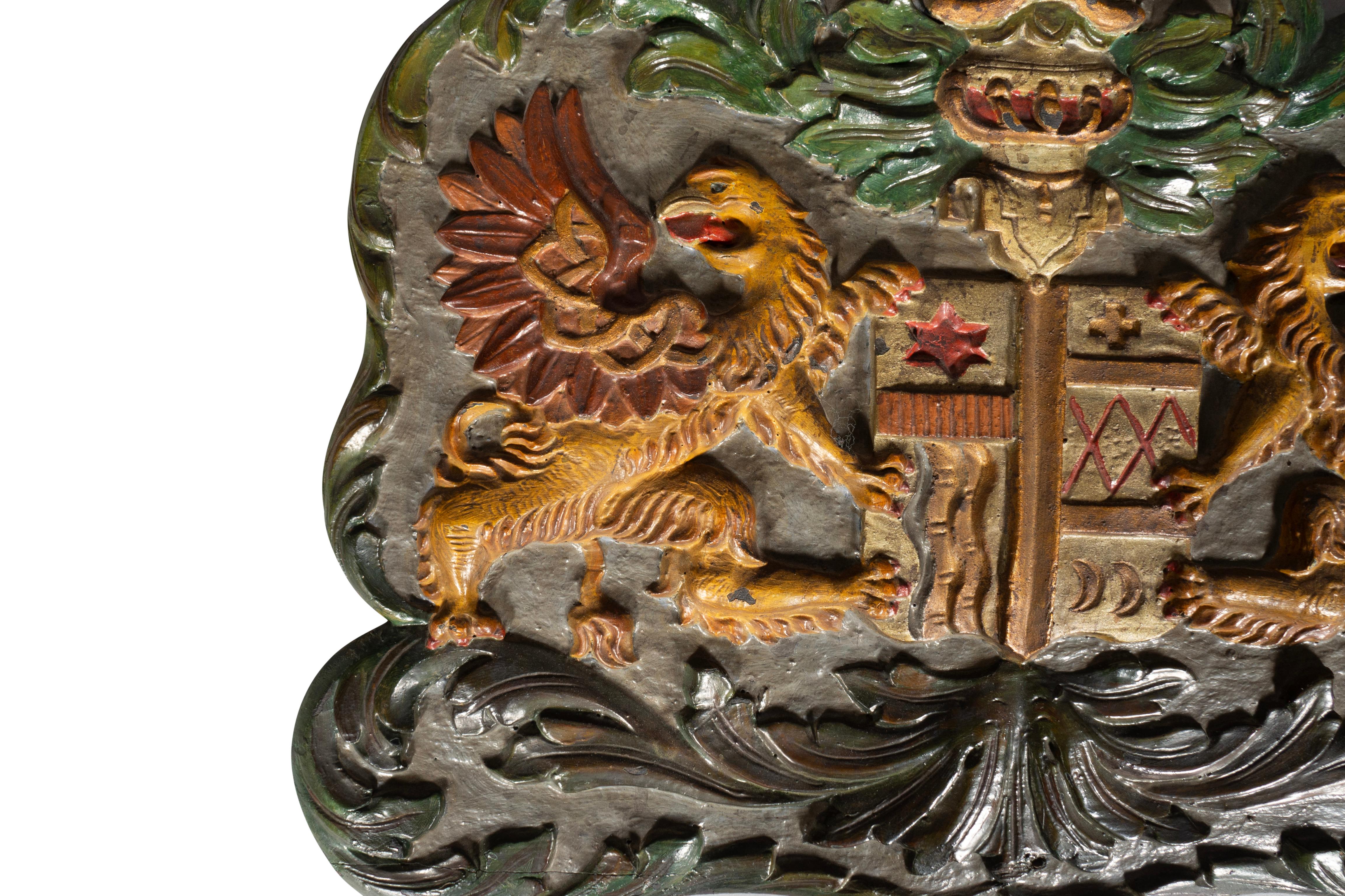 Featuring a pair of winged griffons flanking a coat of arms with helmet.