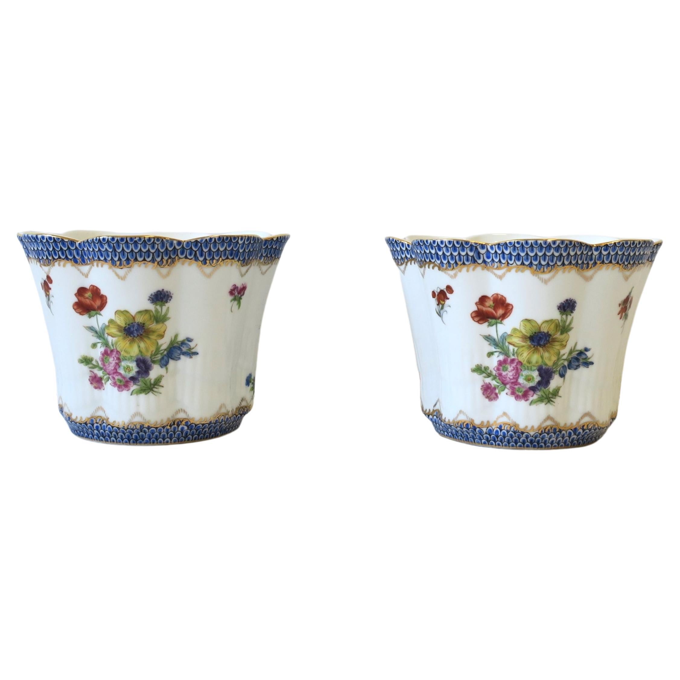 A beautiful pair of European porcelain flower or plant pot holders jardinieres or planter cachepots with flower and leaf design, circa mid-20th century, Europe. In the Herend or Sevres style. Jardinieres or cachepots have a flower and leaf design on