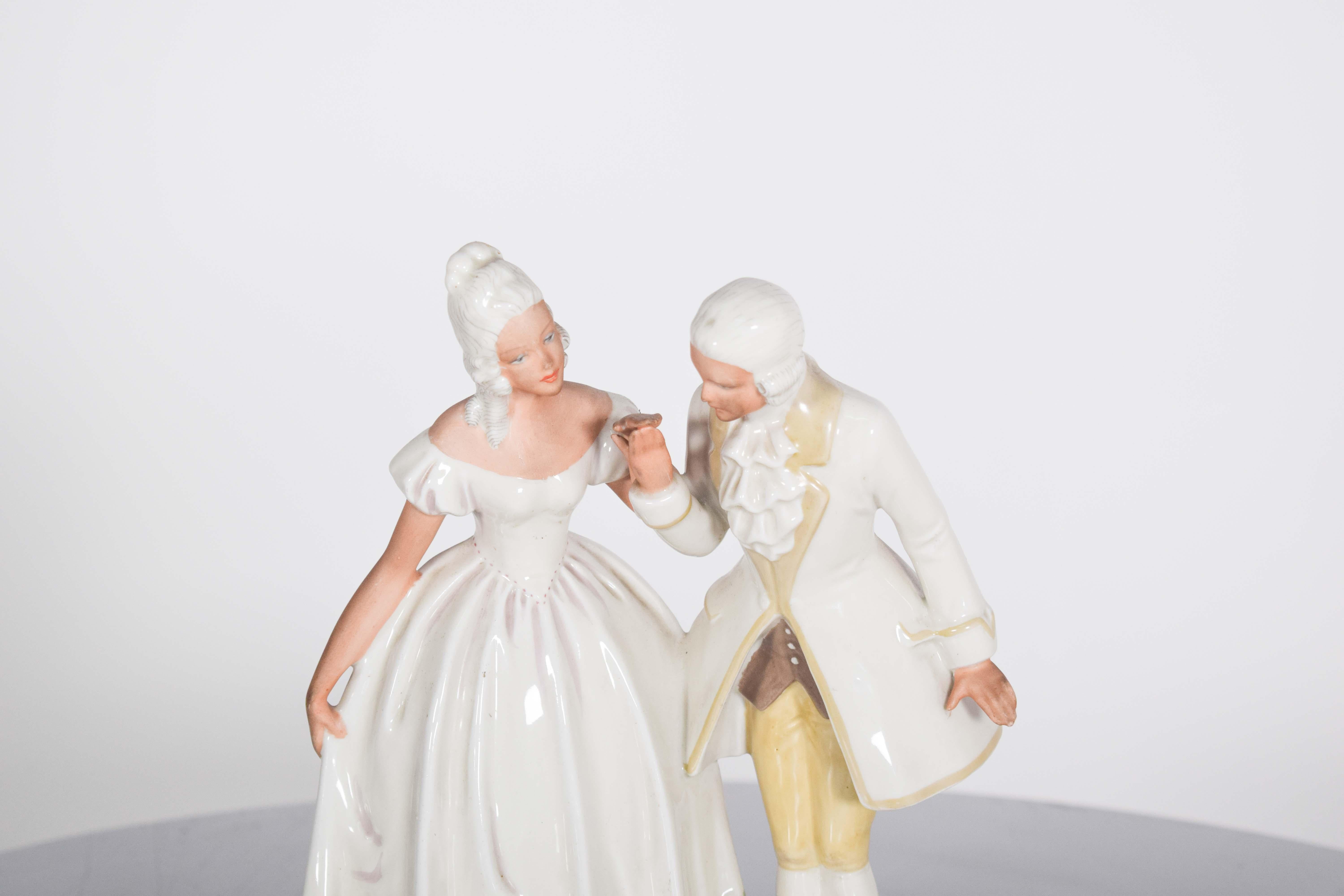 Figuras escultóricas de porcelana europea, que representan a una pareja bailando. Decoración policromada predominantemente blanca, con delicados detalles policromados que añaden suavidad y vida a la pieza.
Las figuras están esculpidas con gran
