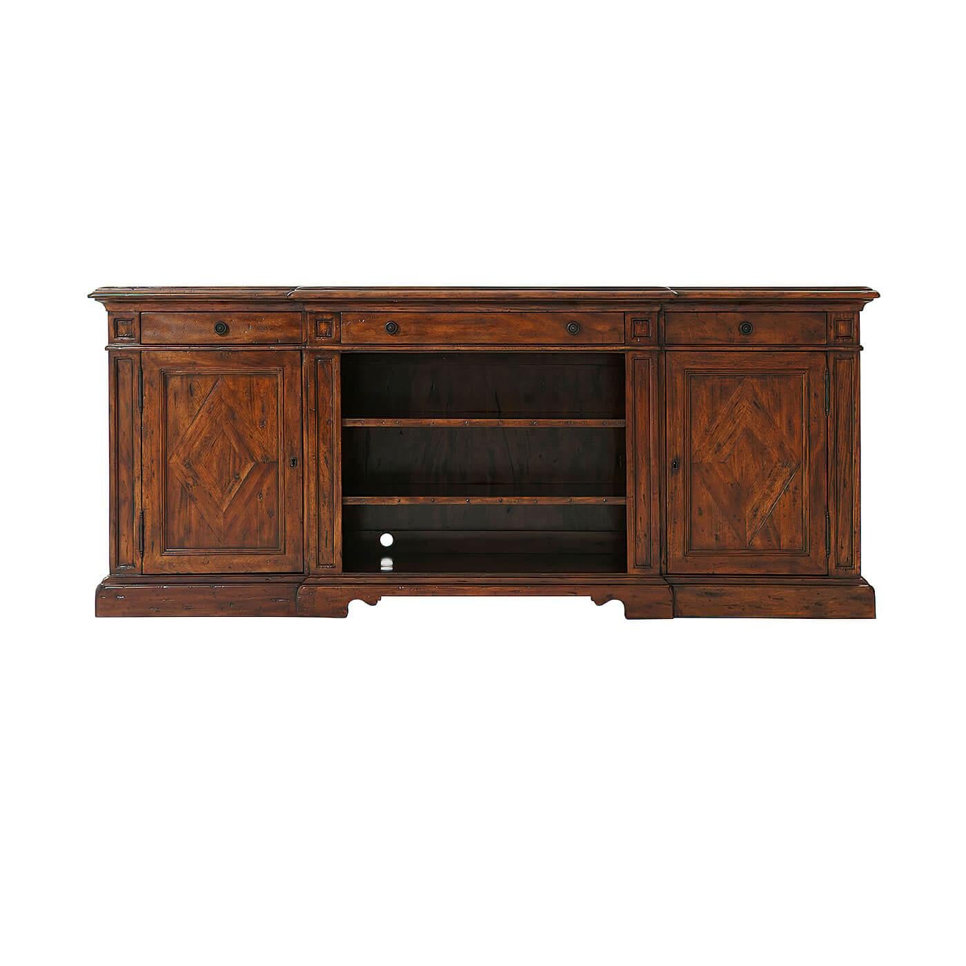 A European antiqued wood breakfront low media console, with three frieze drawers with verdigris brass handles open central section, on bracket feet. The side cabinets each enclosing an adjustable shelf.

Dimensions: 73.25