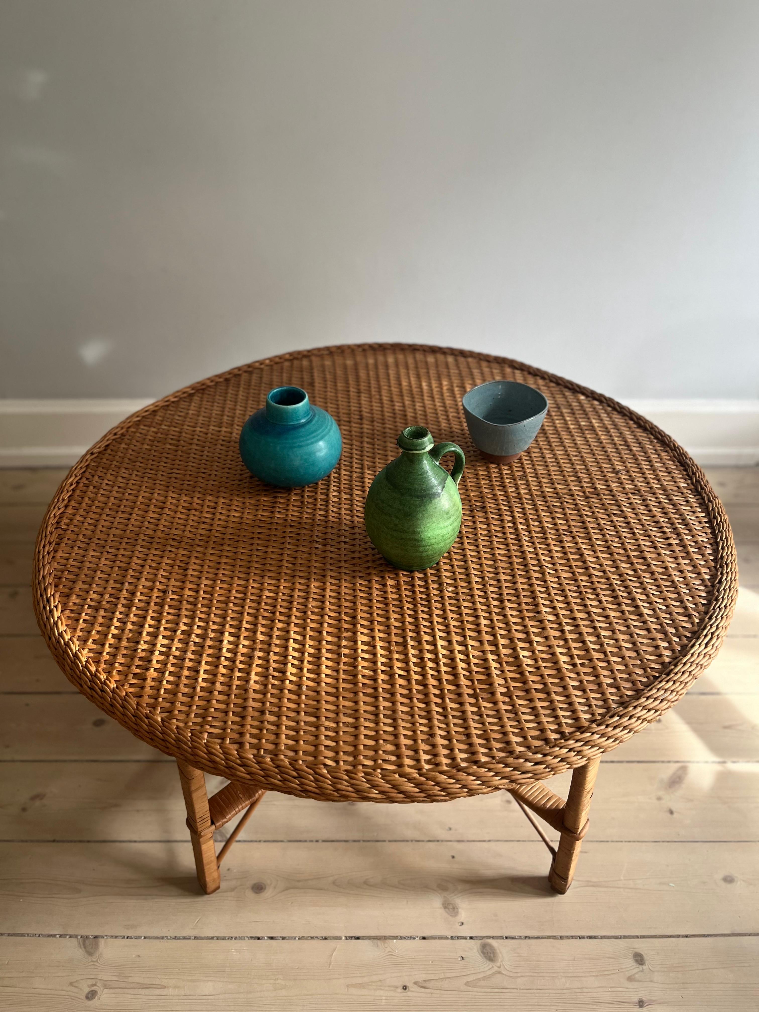 Grande tavolino in rattan degli anni '70 circa.

il tavolo ha una base delicata che lo rende bello da vedere - da davanti, da dietro e di lato. 

il piano rotondo del tavolo offre spazio a più persone intorno e in compagnia di poltrone, il tavolo si