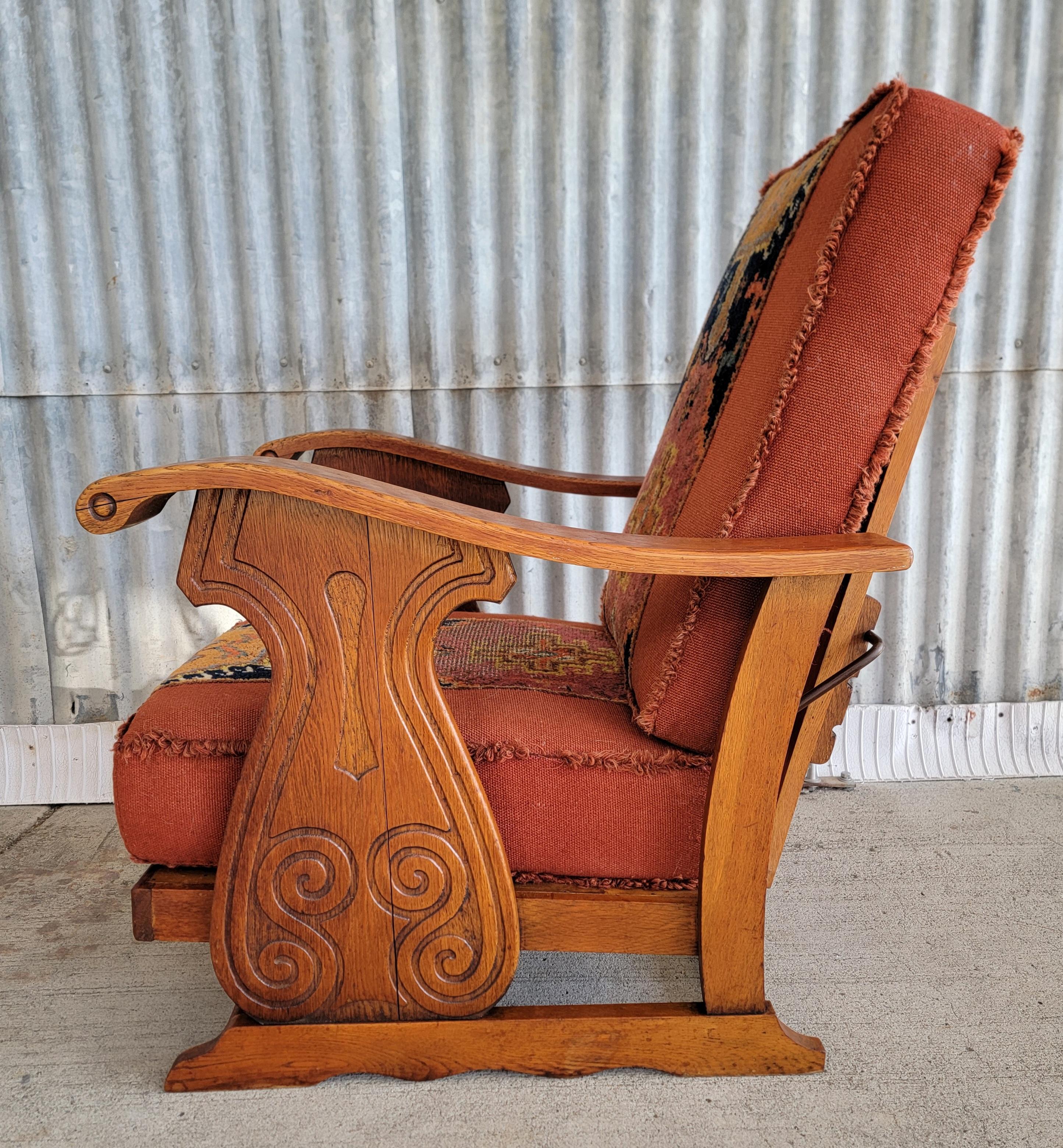 Unusual European carved oak reclining lounge chair with original Turkish rug style upholstery. Circa. 1950's. Crafted in solid oak with 3 adjustable positions. Metal rod makes adjustments similar to a Morris Chair. Nice glow to the original finish.