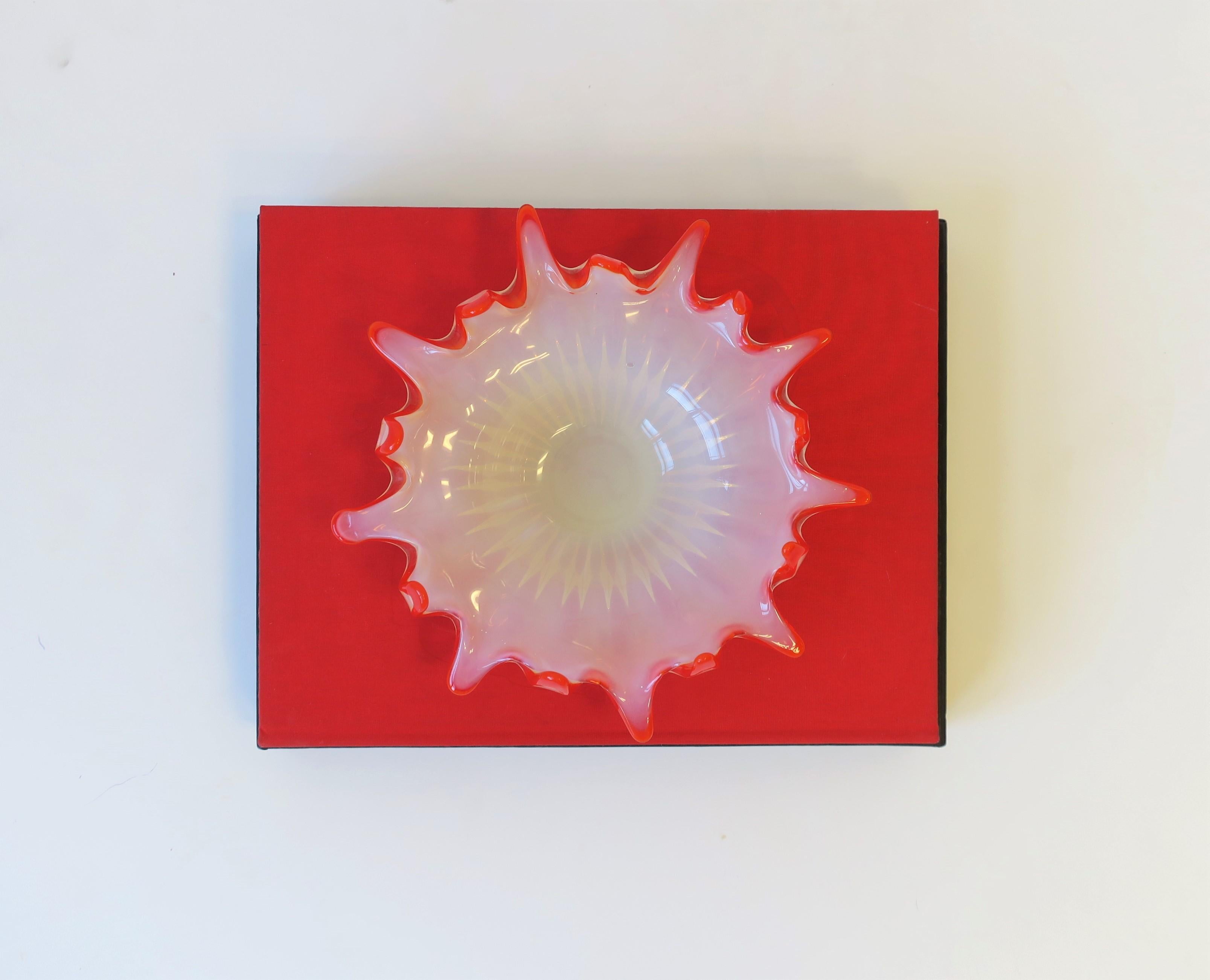 A Midcentury Modern art glass bowl in red and white opaline, circa mid-20th century. White opaline art glass bowl has a fluted base and red trim/edge design. Bowl is a nice size measuring: 10.5