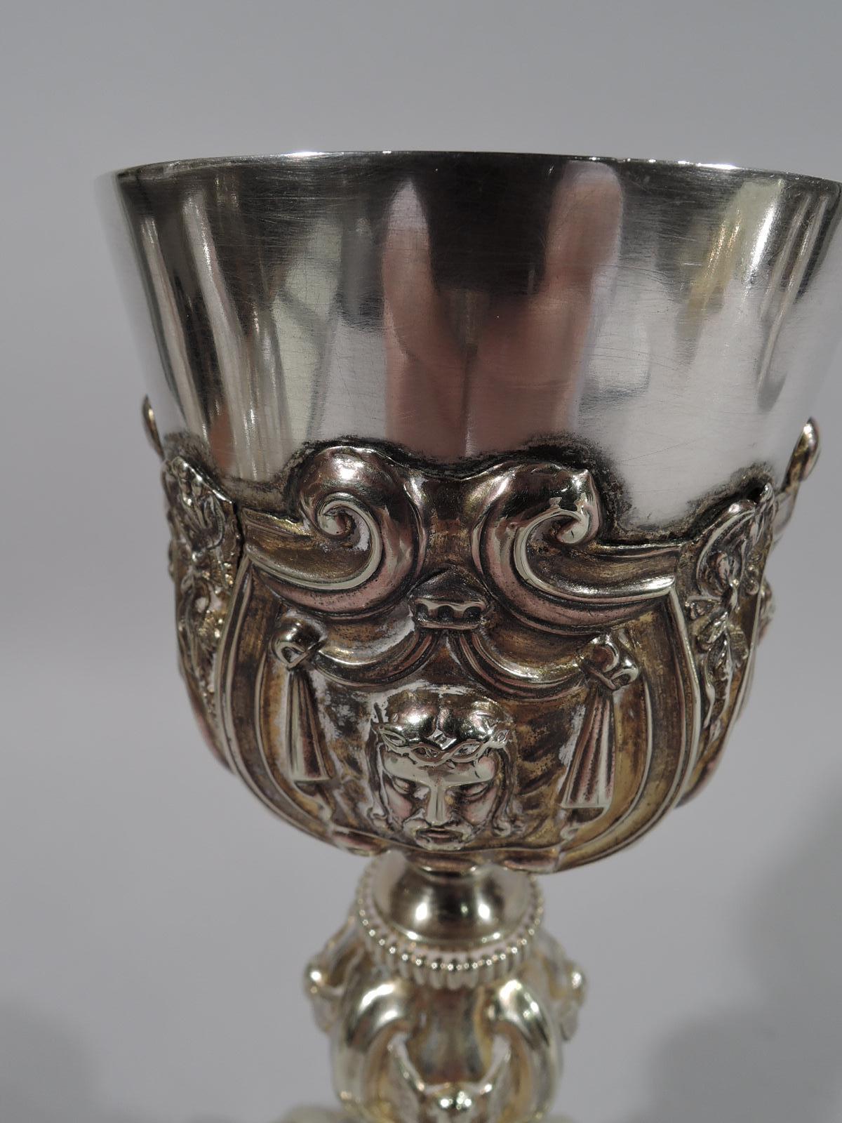 Antique European Renaissance Revival silver gilt chalice, circa 1850. Bowl on baluster shaft on shaped, domed, and stepped foot. Chased scrolls framing religious imagery. On bowl, the veil of Veronica interspersed with pendant branches. On foot, are