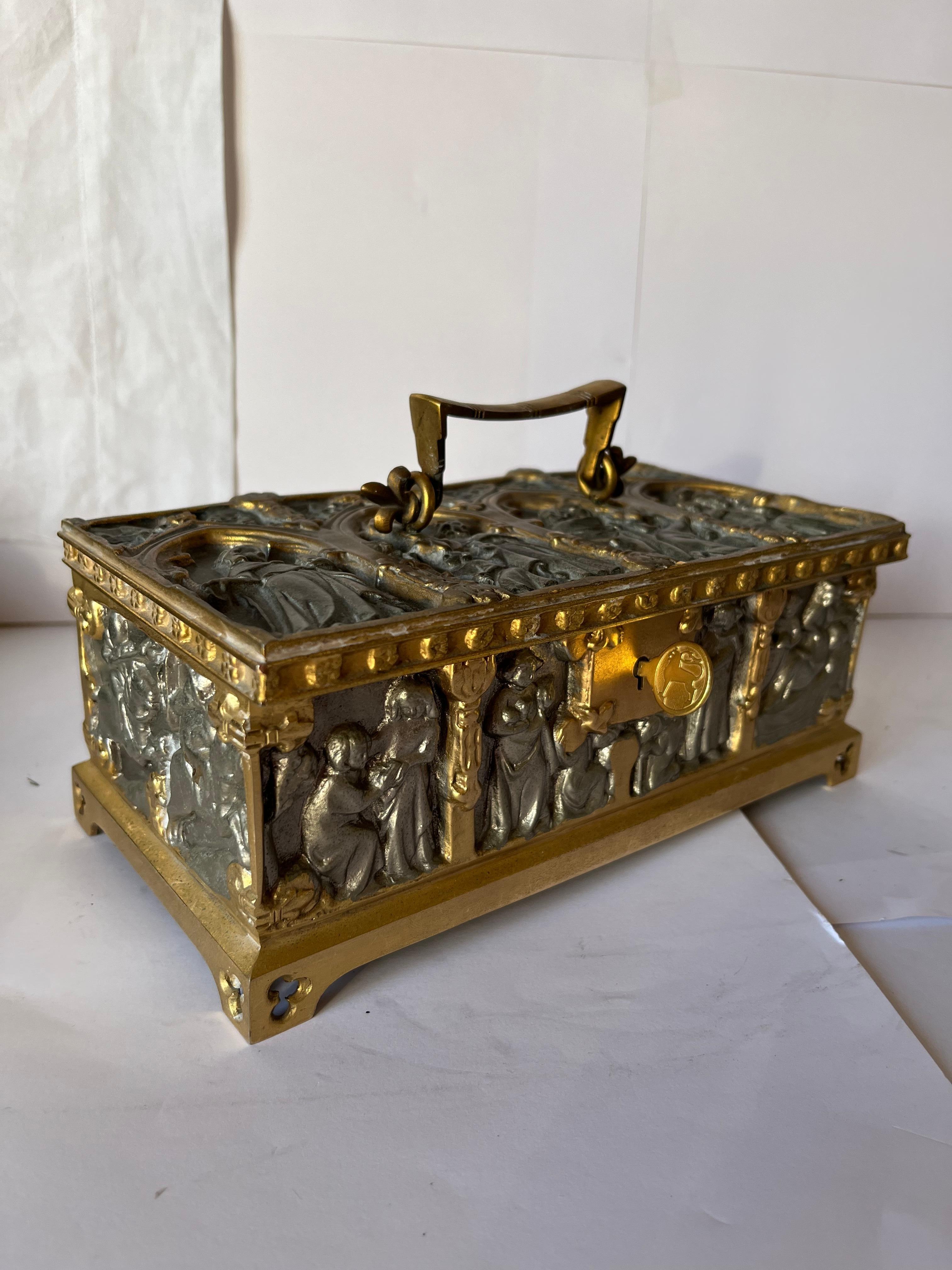 Middle age Gothic European Renaissance style for the jewelry box in steel with golden parts.
We recognize middle age figures all around and on the top of the box and the renaissance architectural design on the top and on each side of the small