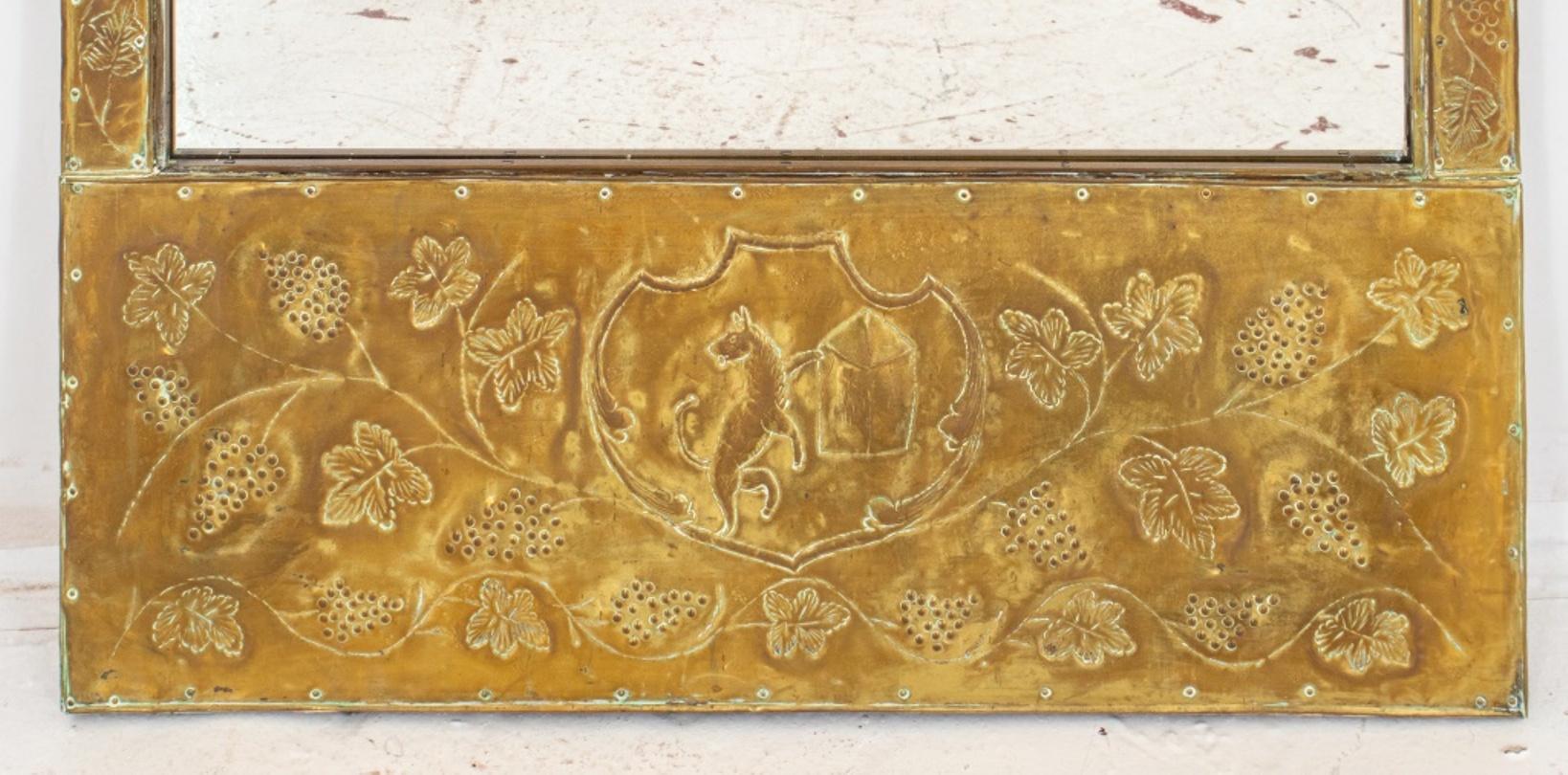 European repousse brass framed mirror, possibly Spanish or Italian, the trumeau with armorial bearings and the rest with an allover grapevine pattern, centering a rectangular mirror plate,

Dimensions: Mirror: 36.5