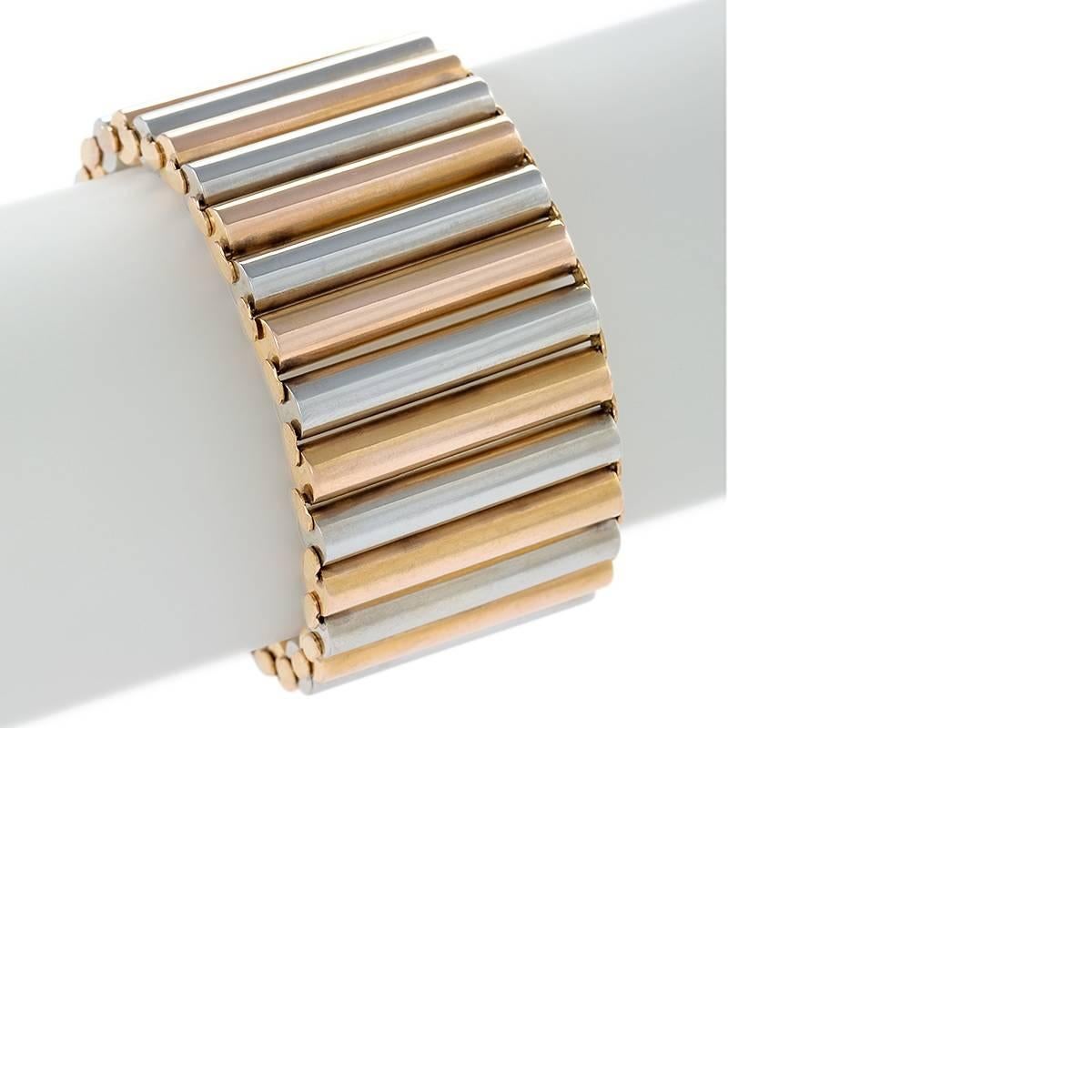 Dating from the 1940s, this flexible European bracelet is composed of alternating rose gold and white gold cylindrical links. Wide, light to wear, and beautifully articulated, this period bracelet is a statement of bold Retro style.

Circa: