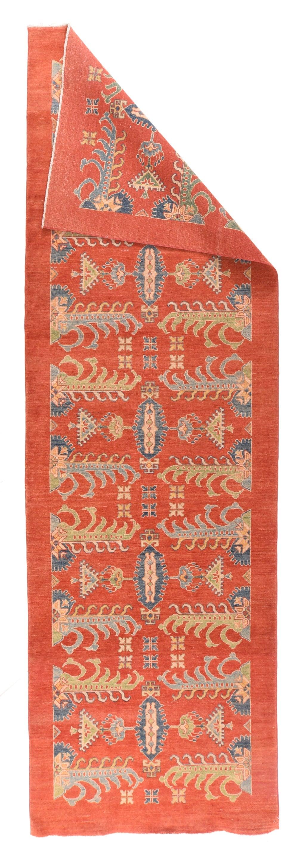 European Rug 3'11'' x 12'10''. The plain rust border sets off five rust cartouches with curly fringe outlines and tall, skinny central plaquettes. Various blues are the salient secondary tones. Flower and 