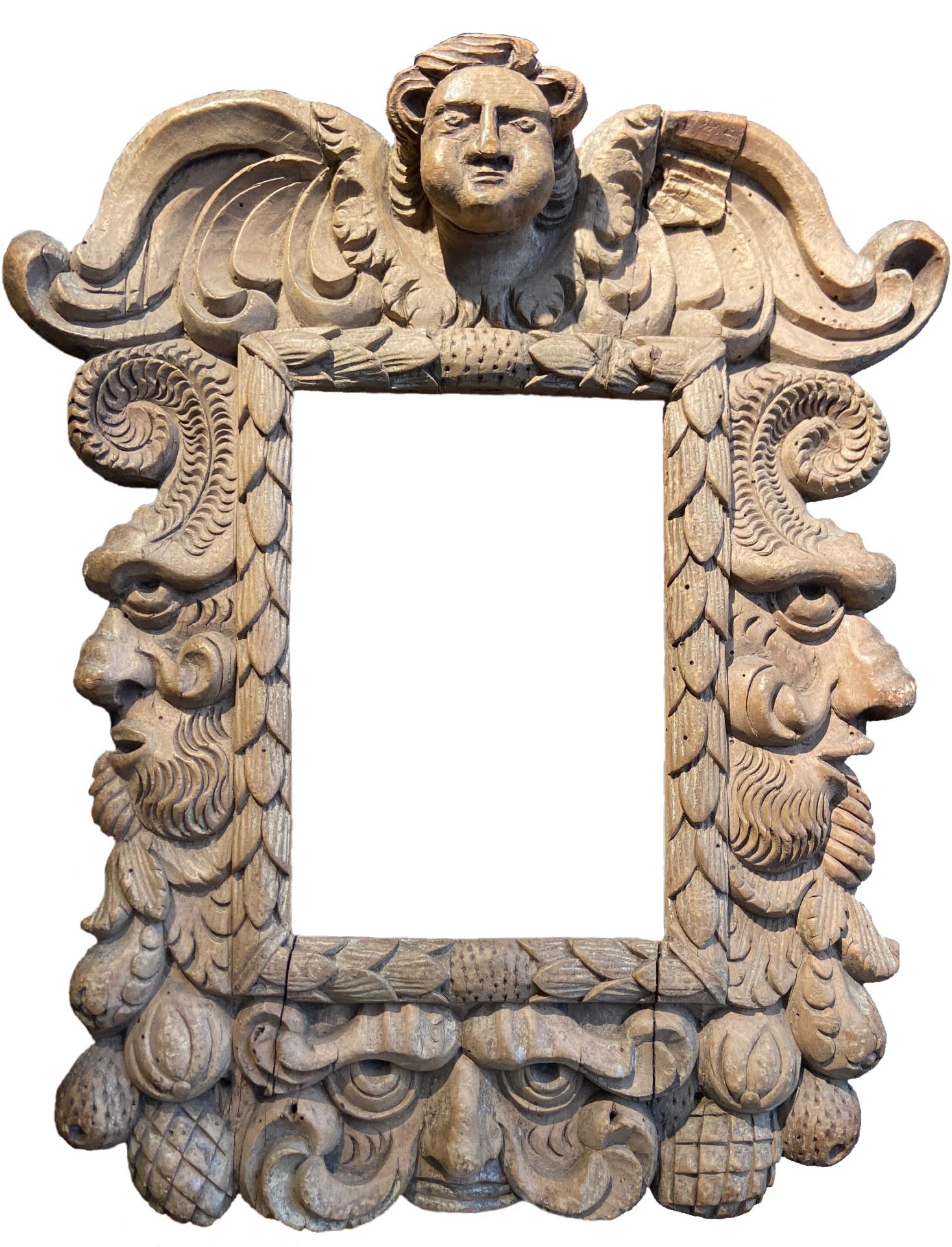 Hand Carved Fruit Wood
Length: 16 inches (40.5 inches)

A striking, richly hand carved frame in high relief. It shows a rich decor of natural organic forms alongside a collection of characterful faces. On the upper part of the frame is a putto on a
