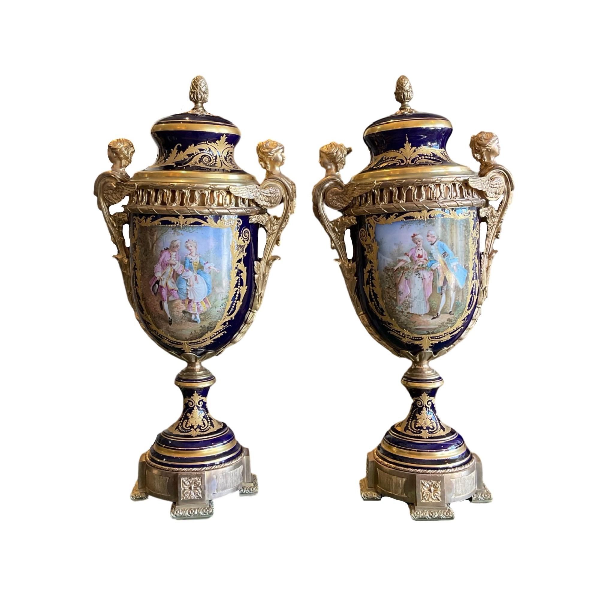 This exquisite pair of 19th-century European Sevres Porcelain Urns are beauty and sophistication personified. Tall blue ceramic vase mounted on a moulded metal stand with metal handles and top of the lid. Handcrafted in Europe with the finest