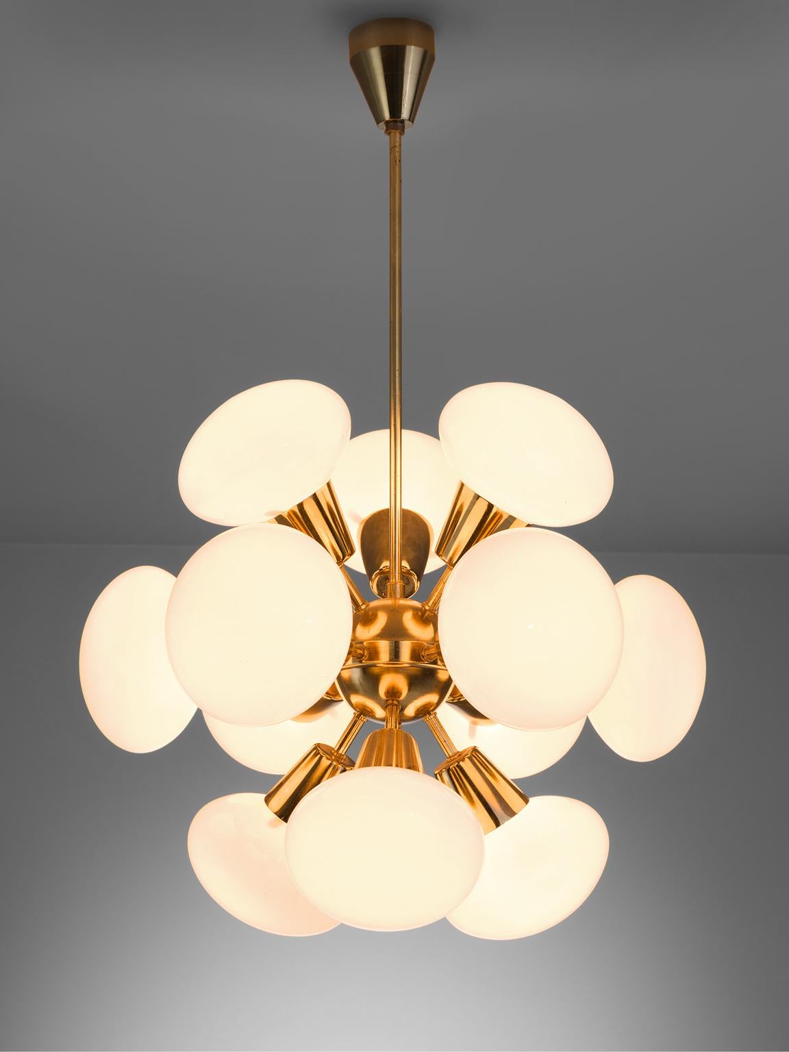 Sputnik chandelier, in brass and opaline glass, Europe, 1970s. 

This small Sputnik features twelve rare 'flat' spheres. The chandelier consists of a brass fixture with 12 arms, all with an opal sphere. The frosted glass these lights create have a