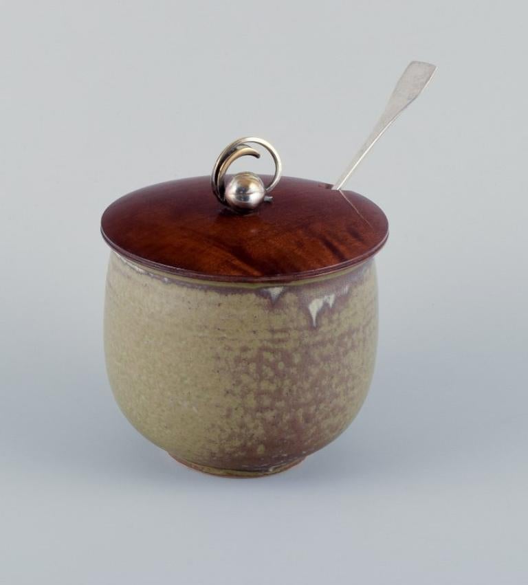 European studio ceramicist and Hugo Grün.
Large ceramic honey jar with a wooden lid, flower bud in plated silver.
Large sterling silver spoon by Hans Hansen.
Mid-20th century.
In perfect condition.
Honey jar: D 12.0 cm x H 13.5 cm.
Silver spoon: L