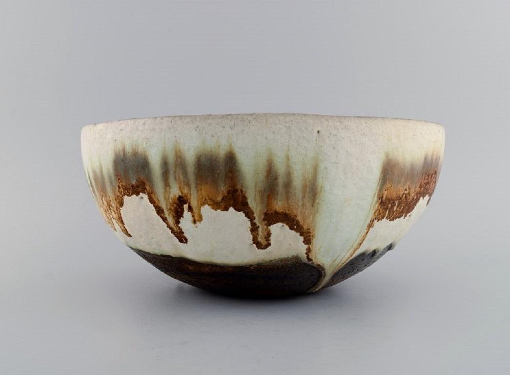 European studio ceramicist. Large unique bowl in glazed ceramics. 
Beautiful running glaze in light earth shades. 1960s / 70s.
Measures: 29.5 x 14 cm.
In excellent condition.