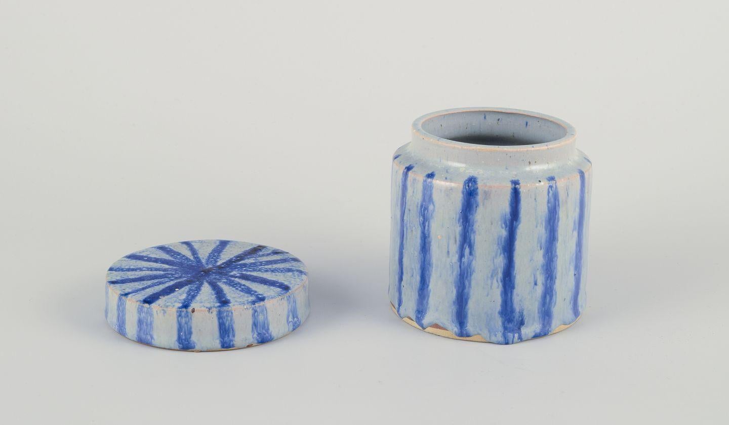 Pre-owned goods are exempt from import duties for U.S. customers. 
Therefore, no import tariffs will be applicable to your purchase.

European studio ceramicist.
Unique lidded jar made of glazed earthenware.
Vertical lines in blue glaze.