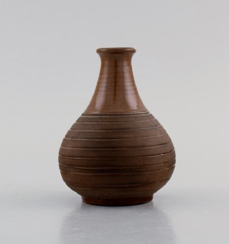 European studio ceramicist. Vase in glazed ceramics with the grooved body. 
Beautiful glaze in brown shades. Dated 1964.
Measures: 9.7 x 7.5 cm.
In excellent condition.
Signed and dated.