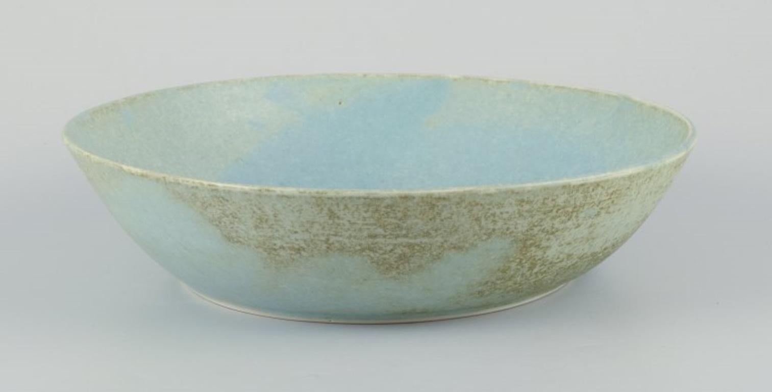 Unknown European studio ceramicist. Very large bowl with glaze in light blue tones. For Sale