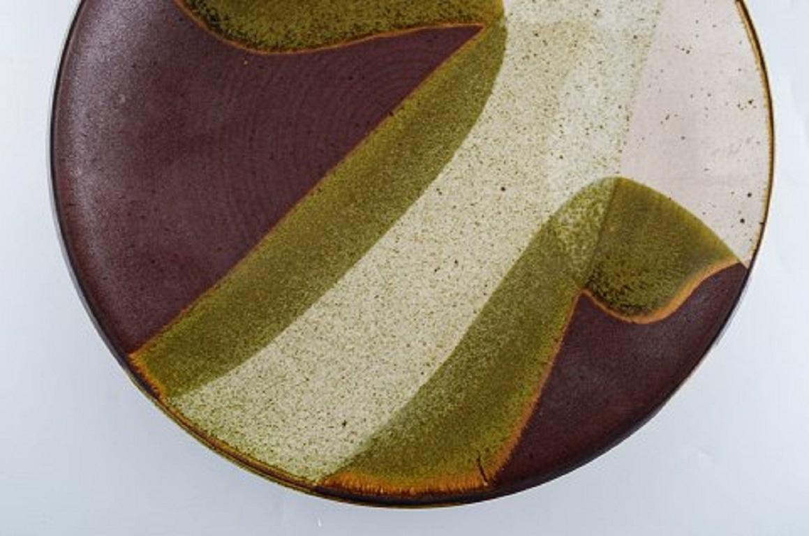 European studio ceramist. Unique dish in glazed ceramics. Dated 1985. Beautiful glaze in gray and olive green tones.
Measure: Diameter: 32 cm.
In very good condition.
Signed and dated.