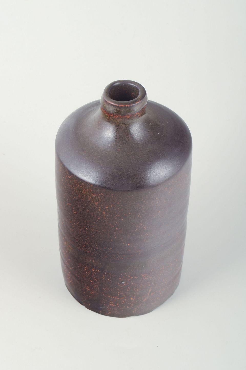 Europäisches Studio Potter. Hohe zylindrische Keramikvase mit einem kurzen, leicht verengten Hals.
Die Glasur ist in einem tiefen Violettton mit rötlichen Sprenkeln ausgeführt, wodurch ein lebendiger, fast metallischer Oberflächeneffekt entsteht.