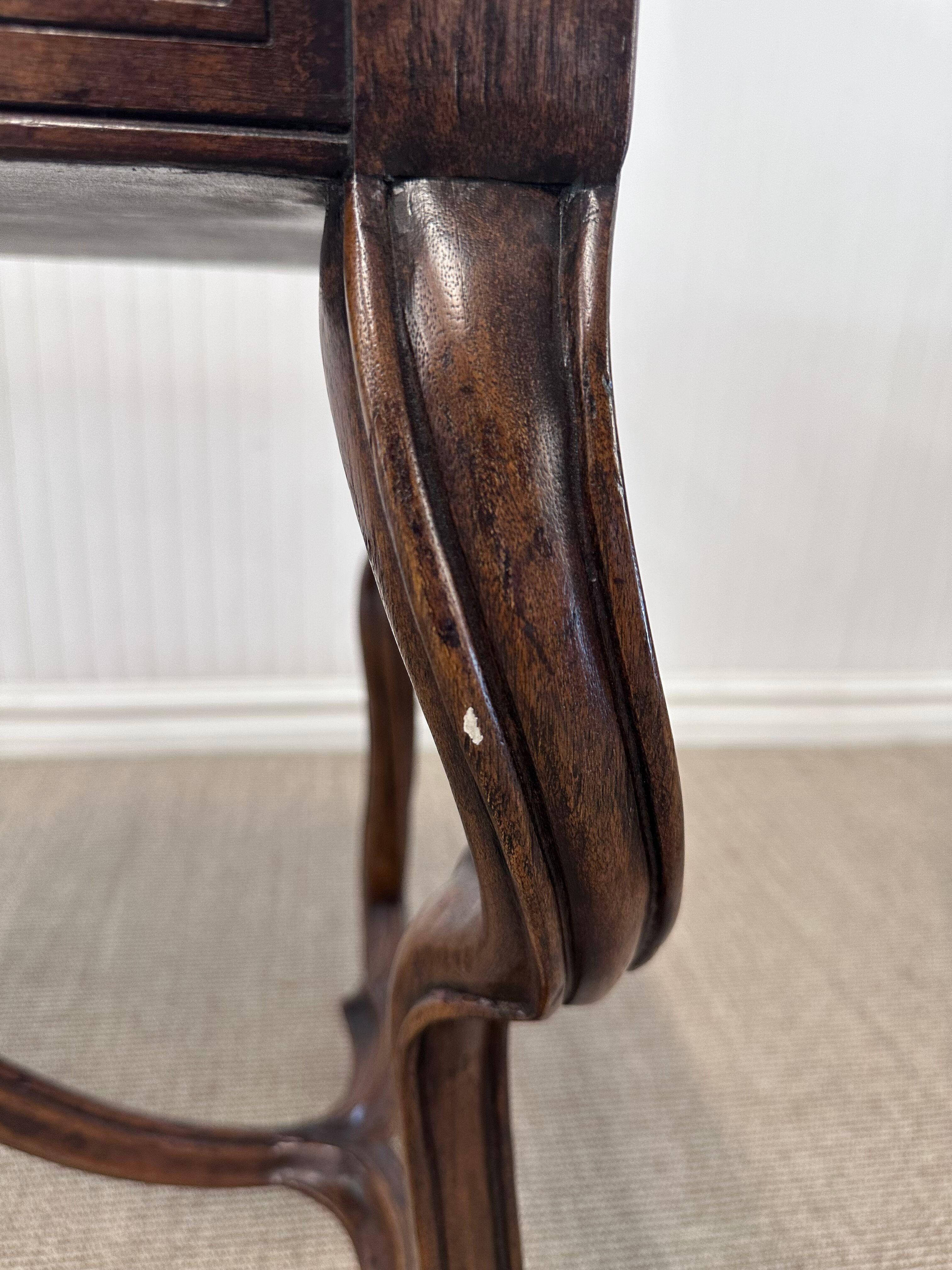 Se trata de un escritorio de nogal de inspiración italiana o española, bellamente elaborado, que exhibe un elegante diseño del Viejo Mundo, con elegantes proporciones y refinados detalles.

Las características principales son:

Tablero y cajón: El