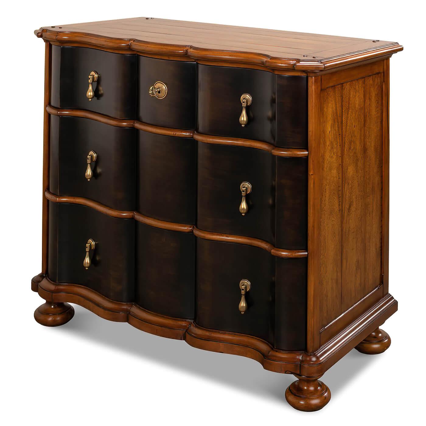 European-style walnut and ebonized chest of drawers, crafted in walnut with a finely figured top. This chest has three shaped drawers with an ebonized front. Each drawer has lovely cast brass 