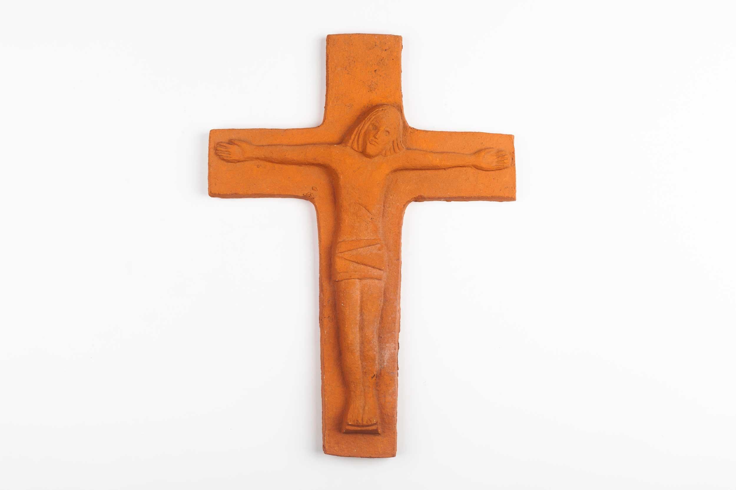 Eleven inch tall wall crucifix in terra cotta. Matte cross in an earthy sienna clay color with an angelic swathed christ figure in volume. This cross is part of a large collection of handmade crosses, all unique and specially made by a 20th century