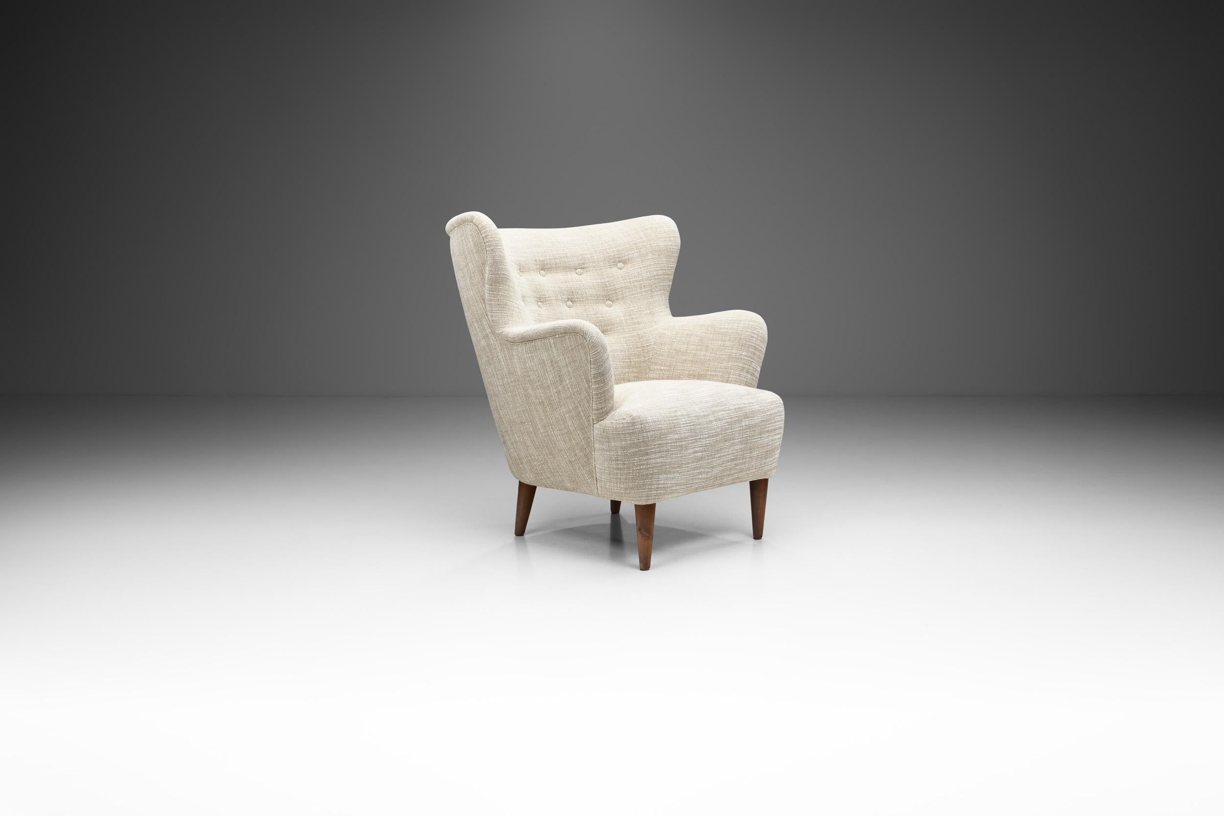 This elegant winged lounge chair is a great representation of the quality and craftsmanship of mid-century European cabinetmakers and the immediately recognizable characteristics of the era’s modernist design.

The welcoming, rounded shape of the