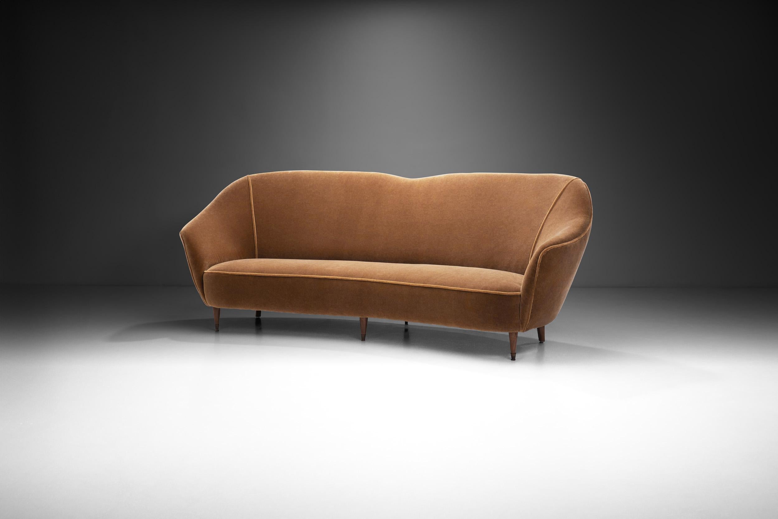 The European perspective on cabinetmaking is exceptional, and wood is omnipresent in mid-century modernism. This sumptuous curved sofa features the immediately recognizable touches of Modernism: exquisite materials, craftsmanship, and an elegantly