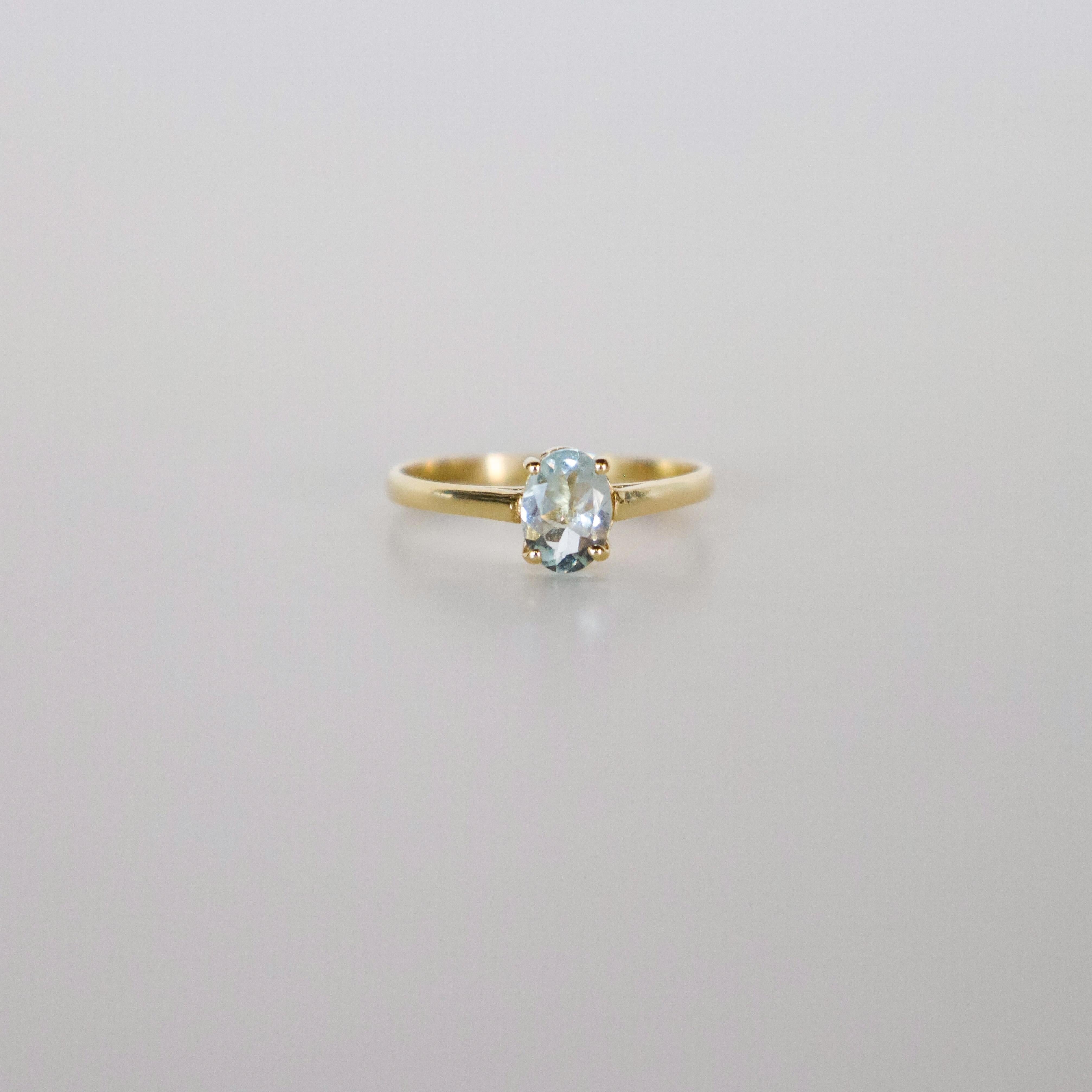 Embrace timeless elegance with this 14k yellow gold solitaire ring, featuring a stunning oval brilliant-cut aquamarine as its centerpiece. Crafted from solid 14k yellow gold, this vintage ring, originating from Spain, highlights the aquamarine’s