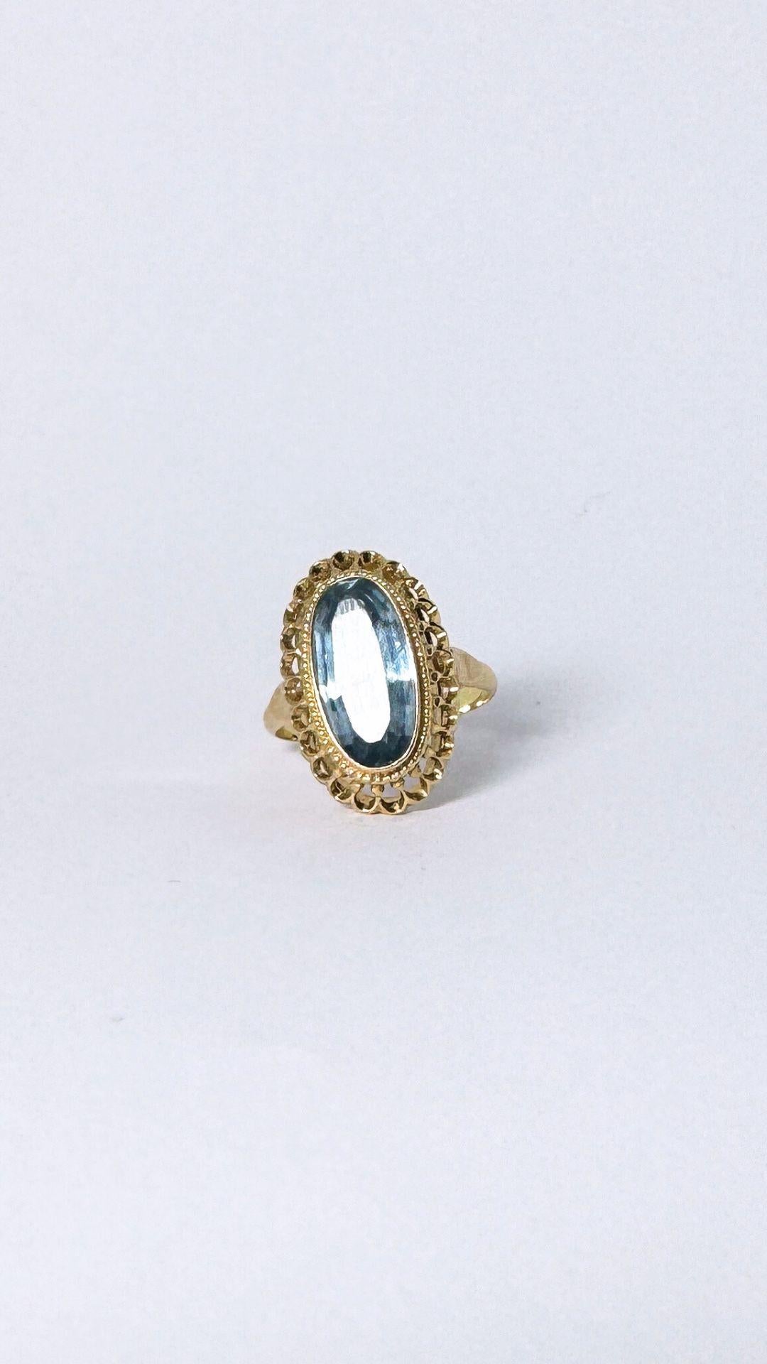 Absolutely adore this pre-loved ring. Look at the design and the elegance of this jewel. This ring is made of yellow gold, 14 carat and is with an oval faceted synthetic spinel of about 5.54 ct. The spinel is set in an open case setting. The ring