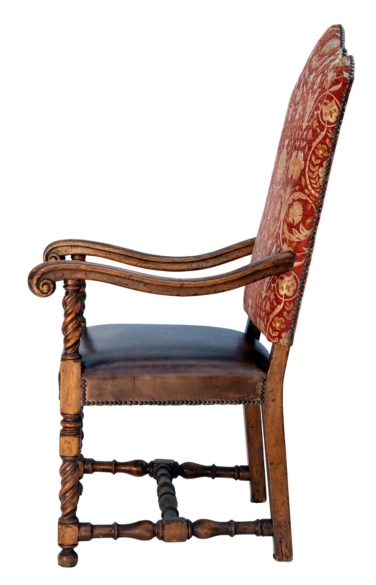 Schöne handgeschnitzte europäische Thronsessel aus Nussbaum um 1900. 
Solide und sehr robust. Später neu gepolstert mit anilingefärbten Ledersitzen und Rückenlehnen aus Stoff mit bronzenen Nagelköpfen. In tadellosem Zustand mit schöner Patina an den