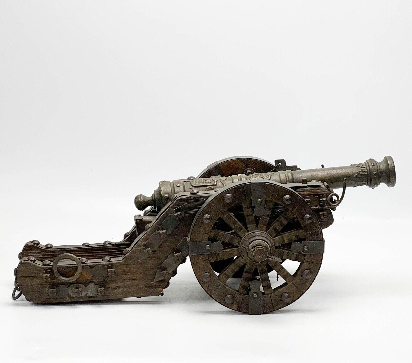 European Wood Iron and Metal Model Cannon with Coat of Arms

Vintage European wood, iron, and metal model cannon. Ornate decoration to cannon featuring a coat of arms. The base the back end of cannon sits on can be adjusted by turning the lever.