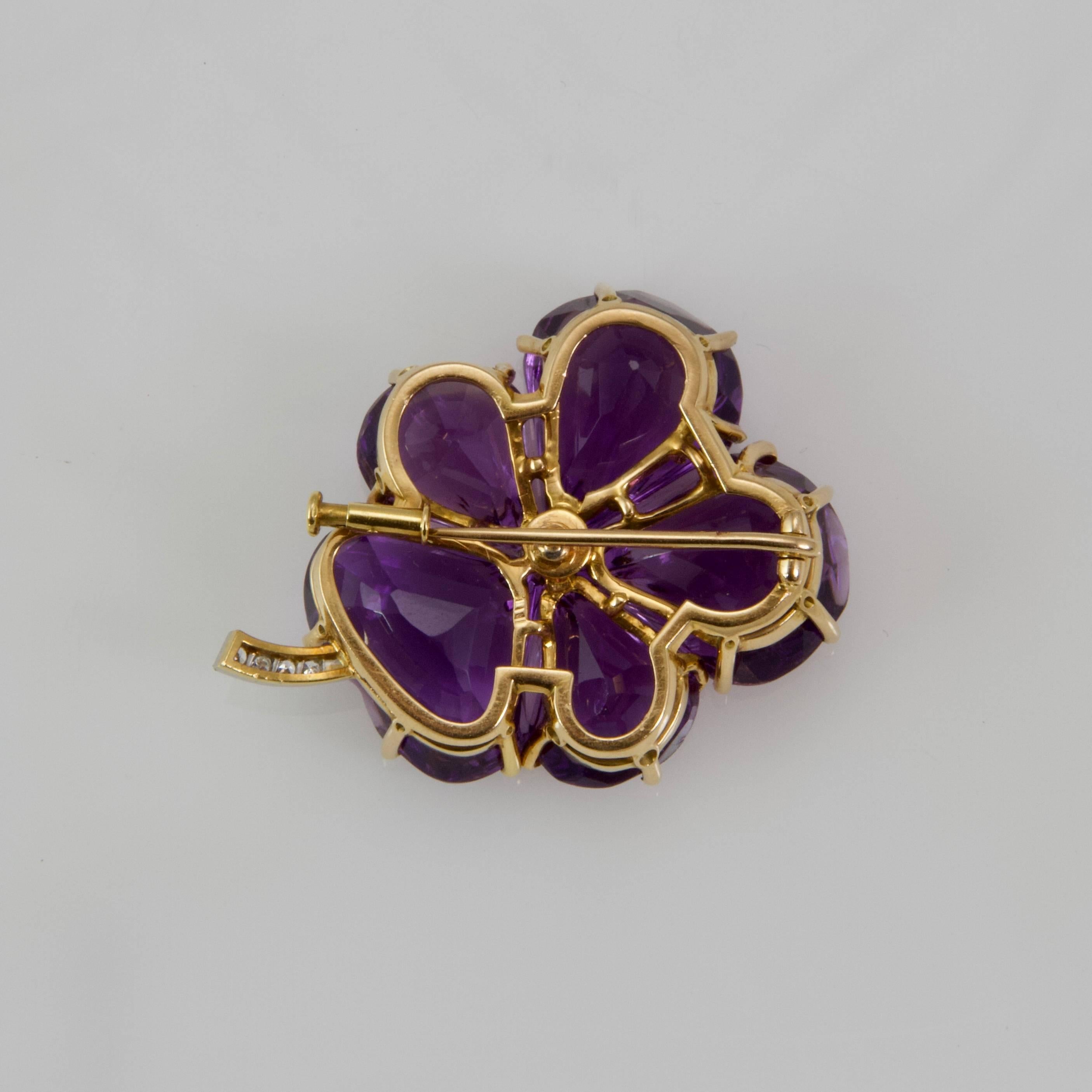 A  pansy brooch set with five amethyst petal shaped centered with a round diamond weight around 0.70 carat on a stem set with four small round diamond. 
Pomp security  system. 
Probably made in England. 
French recense marks for 18kt gold