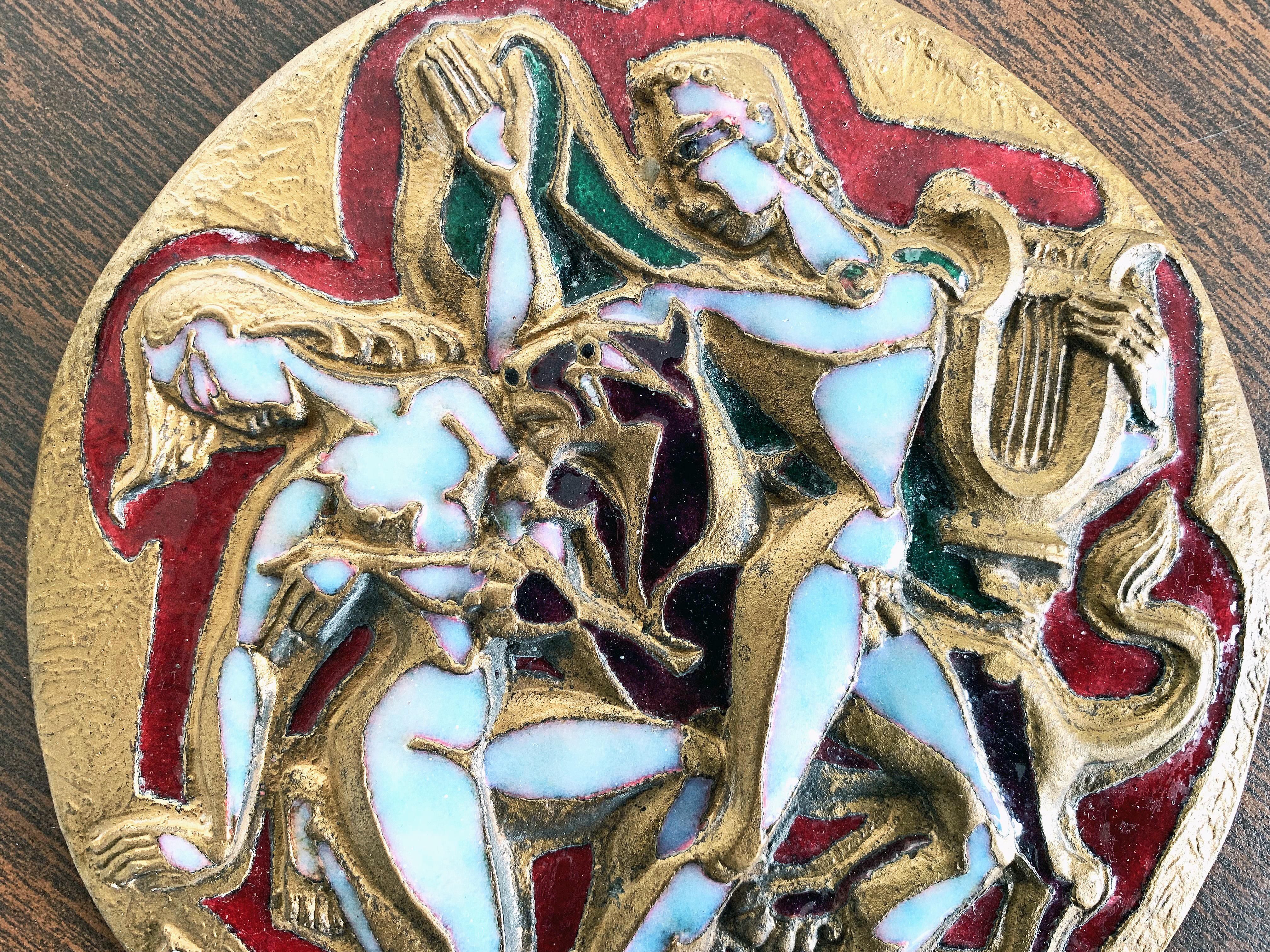 Boldly sculpted in gilded bronze and gorgeously enriched with several shades of enamel, including mother of pearl and ruby red, this midcentury rondel depicts two nude figures Orpheus and Eurydice with a lion rearing between them. Orpheus is